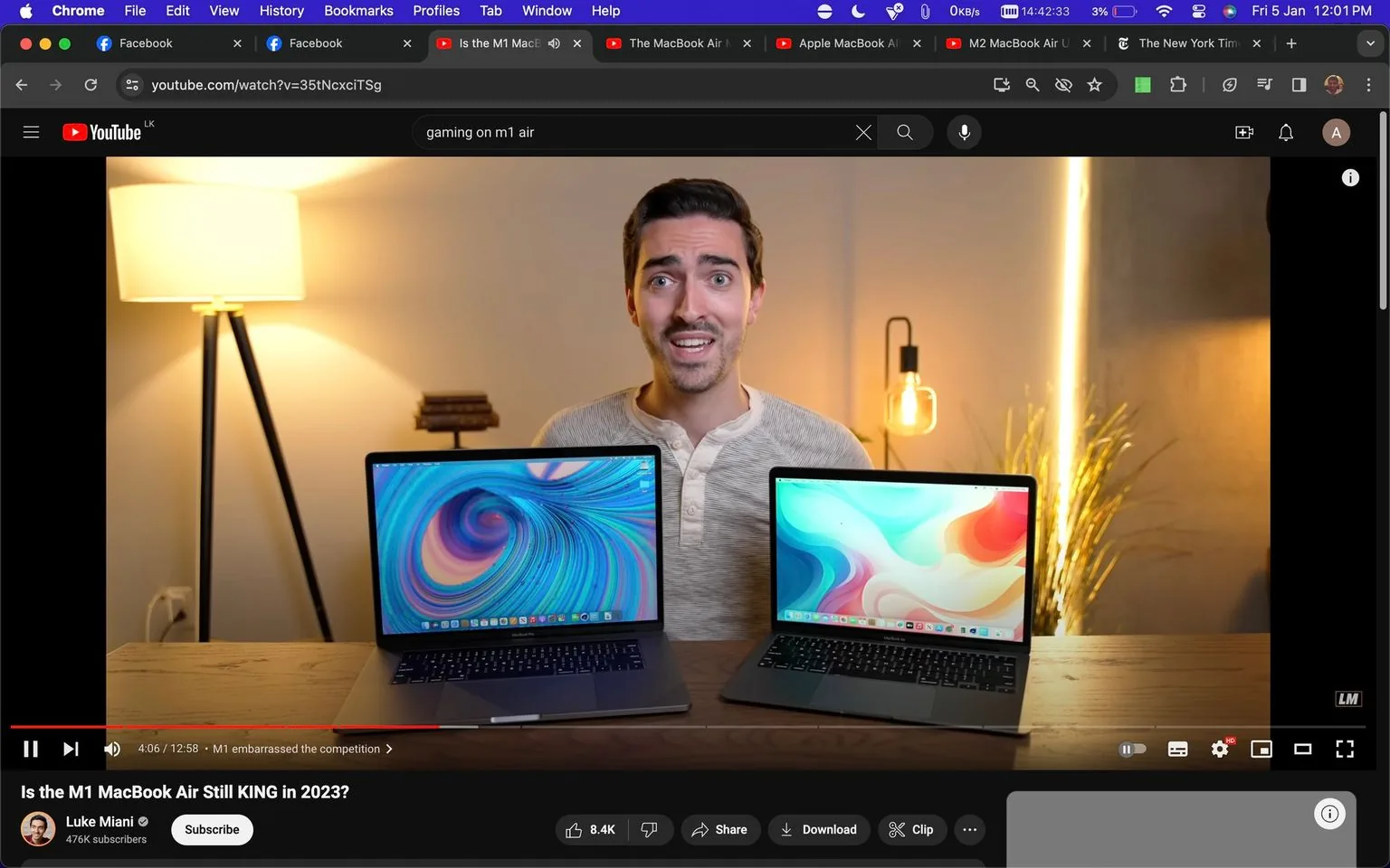 The image is a screenshot from a YouTube video titled "Is the M1 MacBook Air Still KING in 2023?" The video is from the channel "Luke Miani." In the foreground, Luke Miani is sitting at a table with two laptops in front of him. He appears to be in a well-lit indoor setting with warm lighting, indicated by a floor lamp on the left and a decorative light bulb on the right. The laptops have colorful, abstract wallpapers displayed on their screens.
Luke is wearing a light-colored shirt and has a neutral to slightly enthusiastic expression, suggesting he is explaining or reviewing something. The background is minimalistic, featuring a cozy ambiance with a light wooden table and some decorative elements. The video seems to be a technology review, focusing on the performance or relevance of the M1 MacBook Air in 2023. The video has an interactive YouTube interface with like, share, and other buttons visible at the bottom. A section of the progress bar is highlighted, indicating the point in the video being shown.