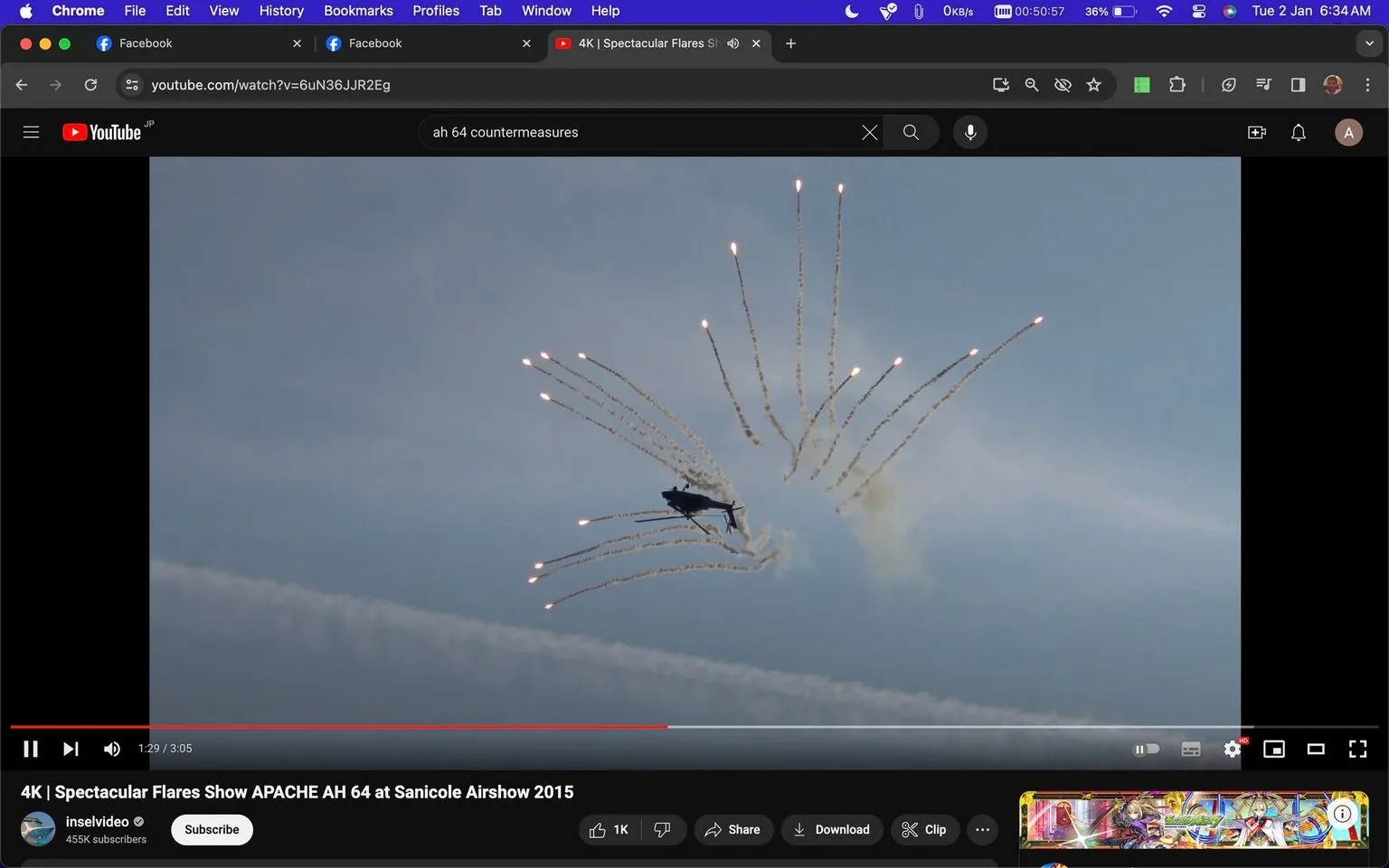 ```
**SECTION 2: Rich Prose Description**
This screenshot captures a moment from a YouTube video titled "4K | Spectacular Flares Show APACHE AH 64 at Sanicole Airshow 2015." The video is hosted on the "inselvideo" channel, which has 455,000 subscribers. In the frame, an AH-64 Apache helicopter is performing a dramatic maneuver, releasing a burst of flares into the sky. The scene is set during an airshow, with the helicopter silhouetted against a clear blue sky. The flares create a striking pattern, fanning out in multiple directions, leaving smoky trails behind them. The helicopter is captured mid-action, showcasing its agility and the spectacle of its countermeasure deployment.
The YouTube interface is visible, with the video timeline showing a play duration of 3:05, and the current time at 1:29. The video has garnered 1,000 likes, and options for sharing, downloading, and clipping the video are available below the player. The browser tabs indicate that the user is also viewing Facebook, with Google Chrome as the browser. The layout is typical of a desktop YouTube interface with a dark theme, enhancing the vividness of the scene depicted in the video.