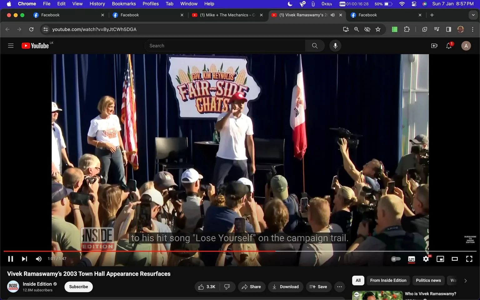 The image is a frame from a video hosted on YouTube, titled "Vivek Ramaswamy's 2003 Town Hall Appearance Resurfaces," published by Inside Edition. It captures an outdoor event with a lively atmosphere, featuring a crowd gathered in front of a stage. The setting is part of "Gov. Kim Reynolds' Fair-Side Chats," as indicated by the sign on stage. At the center, a person is holding a microphone, engaging with the audience. They are wearing a white shirt and a red cap, suggesting a casual, approachable style.
In the background, the stage is adorned with an American flag and another flag, likely symbolizing a state. The event appears well-attended, with numerous people documenting the moment using phones and cameras. The lighting is bright and sunny, indicating daytime. People in the crowd seem attentive and engaged, focusing on the speaker. The video mentions the song "Lose Yourself," indicating a musical element to the appearance. The overall mood is energetic and participatory, typical of political campaign events.
- Title: "Vivek Ramaswamy's 2003 Town Hall Appearance Resurfaces"
- Channel / profile: "Inside Edition"
- Site / app: "YouTube"
- Captions / subtitles: "to his hit song 'Lose Yourself' on the campaign trail."