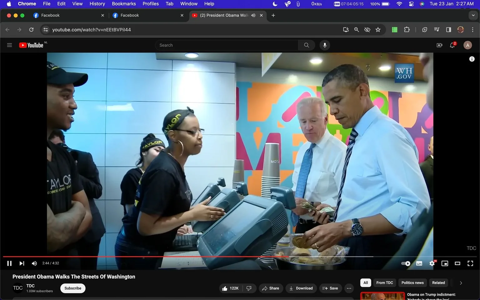 Rich description:
This image is a screenshot from a YouTube video titled "President Obama Walks The Streets Of Washington" on the TDC channel. It captures a moment inside a restaurant setting where Joe Biden and Barack Obama are interacting with staff members at an order counter. Barack Obama is seen handling some food items, likely placing an order, while Joe Biden is standing beside him holding what appears to be a wallet. Both are dressed formally, with Barack Obama wearing a light blue dress shirt and a striped tie, and Joe Biden in a white shirt with a blue tie. The atmosphere is casual as they engage with the staff, who are wearing uniforms with "TAYLOR" branding. The background features a colorful wall, adding a vibrant contrast to the neutral tones of the restaurant interior. The lighting is bright and evenly distributed, contributing to the clear visibility of the scene. This moment highlights a public interaction, showcasing a relatable and approachable side of the political figures.
On-screen text block:
- Title: "President Obama Walks The Streets Of Washington"
- Channel / profile: "TDC"
- Site / app: "YouTube"