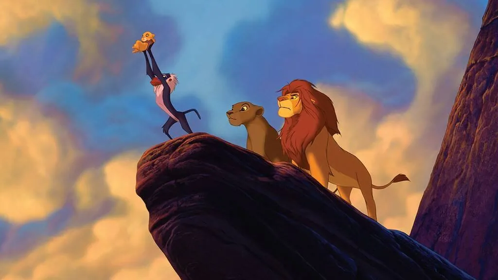 This image is a scene from the animated film "The Lion King." It portrays the iconic moment where Rafiki, a wise mandrill, holds up Simba, a young lion cub, over the edge of Pride Rock. Rafiki is standing on two legs, lifting Simba high into the air with both arms, symbolizing the presentation of the future king to the animals of the Pride Lands. Beside Rafiki stand Mufasa and Nala, the majestic adult lions, looking on with a sense of pride and authority. Mufasa has a regal mane and a strong, confident expression. The sky in the background is a beautiful blend of blue and orange hues, suggesting either dawn or dusk, adding a dramatic and awe-inspiring atmosphere to the scene. The composition emphasizes Simba's importance, with all characters positioned on a high rock, overlooking the kingdom. This vivid illustration captures a pivotal and emotional moment in the storyline, highlighting themes of heritage and destiny.