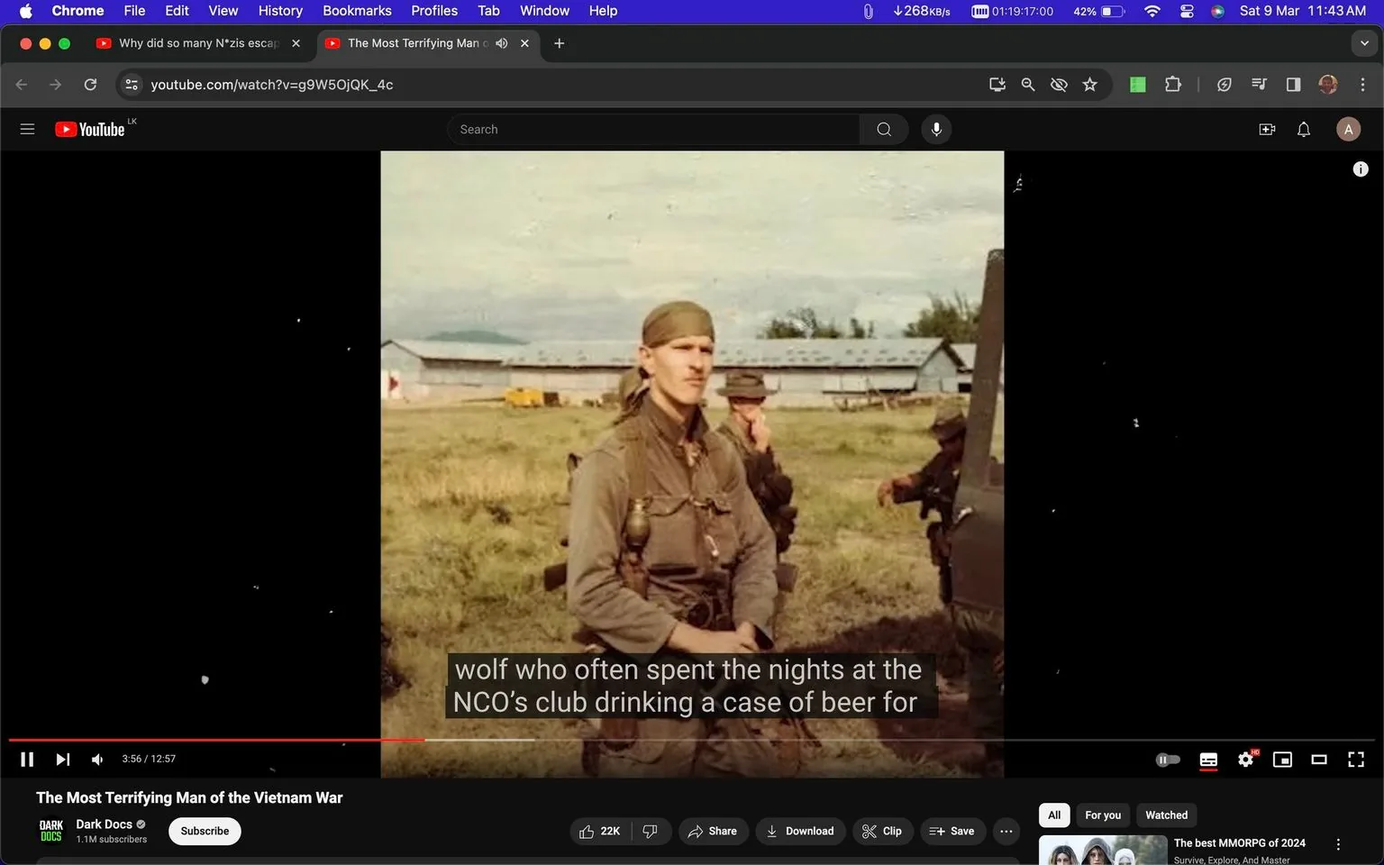The image is a screenshot from a YouTube video titled "The Most Terrifying Man of the Vietnam War," hosted on the channel "Dark Docs." In the foreground, there's a soldier wearing a uniform and a bandana, standing in a grassy field. He appears serious and focused, suggesting a military or historical context. In the background, there are several buildings with slanted roofs, possibly military barracks or storage facilities, under a slightly overcast sky. Another soldier is partially visible near a vehicle, adding to the military setting. The lighting is natural, indicating it might be daytime. The on-screen subtitles read, "wolf who often spent the nights at the NCO’s club drinking a case of beer for," suggesting a narrative about a specific individual's habits or personality during the Vietnam War era. The composition and choice of colors give the image a historical feel, aligning with the documentary's theme.
- Title: "The Most Terrifying Man of the Vietnam War"
- Channel / profile: "Dark Docs"
- Site / app: "YouTube"
- Captions / subtitles: "wolf who often spent the nights at the NCO’s club drinking a case of beer for"