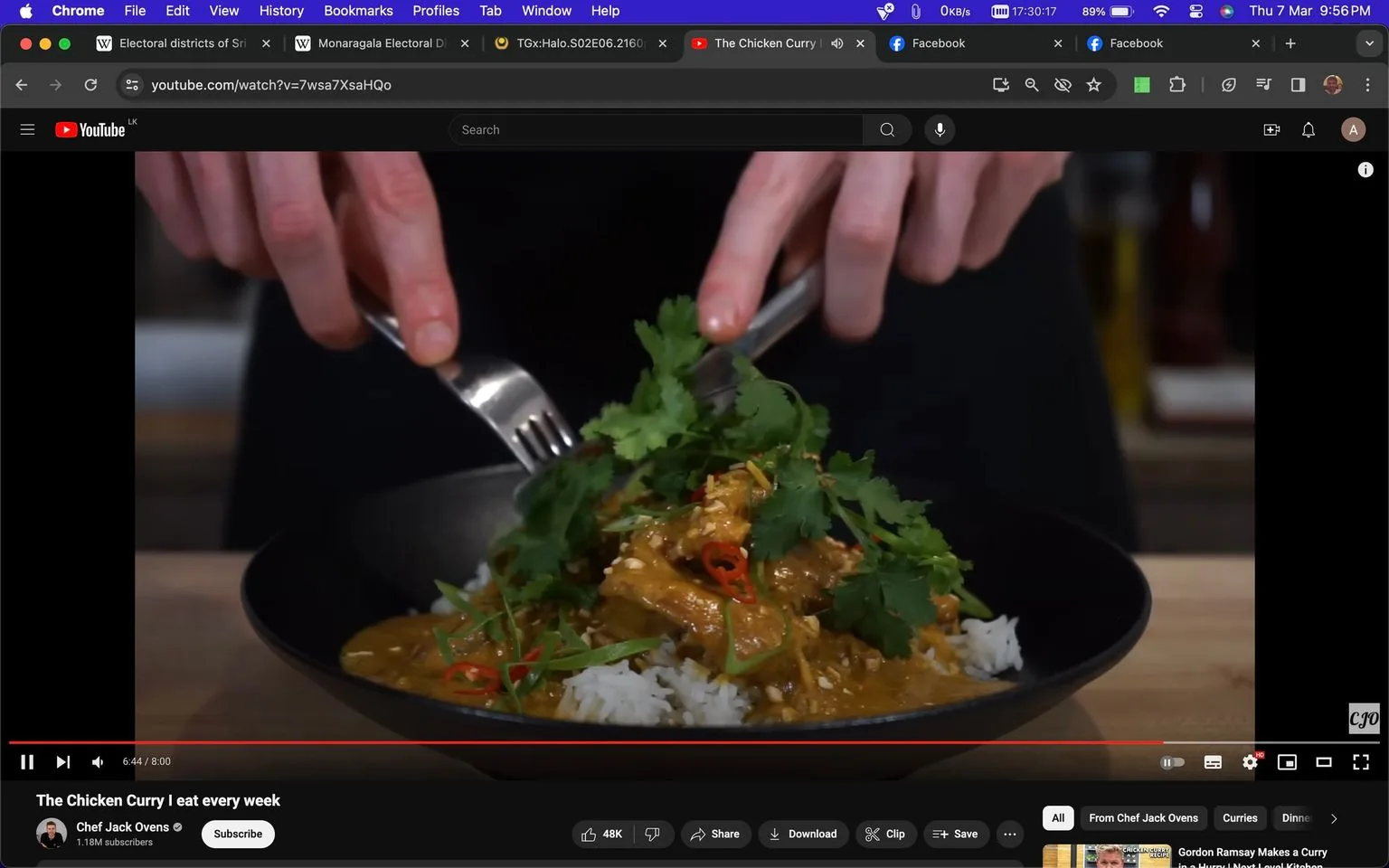 The image is a still from a YouTube video titled "The Chicken Curry | I eat every week," featuring Chef Jack Ovens. It shows a close-up view of a dish being prepared, with hands holding a fork and spoon, ready to serve or mix. The dish consists of rice topped with chicken curry, garnished with fresh cilantro and sliced red chilies, adding vibrant green and red colors to the presentation. The curry appears rich and creamy, with the cilantro giving it a fresh touch. The setting is likely a kitchen, given the presence of cooking implements and ingredients in the background. The lighting is bright, highlighting the colors and textures of the dish. The video is hosted on YouTube, as indicated by the interface elements visible around the video player, such as the like, share, and save options. Chef Jack Ovens' channel has a significant following, with 1.18 million subscribers, suggesting that his recipes are popular and well-received by viewers.