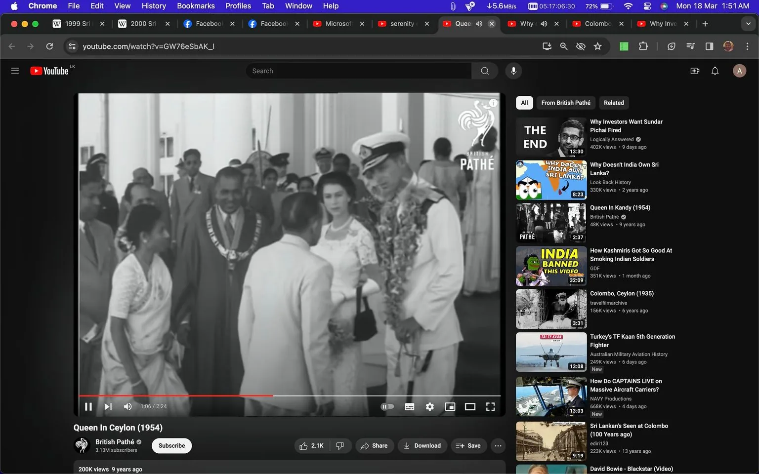 The screenshot displays a black-and-white video titled "Queen In Ceylon (1954)" from the British Pathé YouTube channel. The scene shows a formal gathering, likely a historical event, taking place indoors. In the foreground, a group of people is engaged in conversation. Among them is a woman in a white dress and pearls, possibly representing a significant figure given the context of the video title, which mentions a queen. Nearby, a man in a naval uniform adorned with a garland is standing attentively.
The background features several other individuals, including men in suits and a woman in traditional attire, indicating a multicultural setting. The video is part of a historical archive, evidenced by the British Pathé watermark. The YouTube interface displays a sidebar with related videos on history and cultural topics, enhancing the educational value of this content. The overall mood is formal and respectful, capturing a moment of cultural significance from the mid-20th century.
- Title: "Queen In Ceylon (1954)"
- Channel / profile: "British Pathé"
- Site / app: "YouTube"