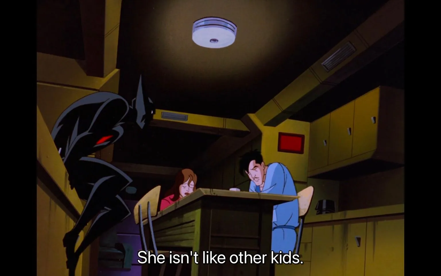 The scene is from the animated series "Batman Beyond." It depicts a dimly lit room with an overcast, moody atmosphere. In the foreground, a character resembling Batman is crouched, partially obscured in shadow, suggesting a stealthy or contemplative posture. The character's suit is dark with a hint of red, typical of the futuristic design seen in the series. In the background, a man and a woman are seated at a table. Both appear tired or distressed, with their heads bowed slightly, creating a solemn mood. The room is filled with yellowish tones, with cabinets lining the walls, contributing to the closed-in, intimate setting. The subtitle at the bottom reads, "She isn't like other kids," hinting at a conversation about a unique or special child. The style is typical of late 1990s animation, with bold lines and a somewhat angular character design.