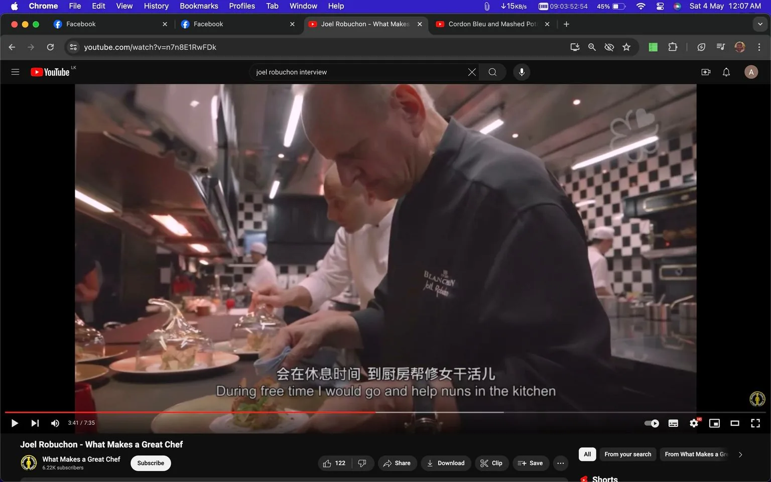 The image is a screenshot from a YouTube video titled "Joel Robuchon - What Makes a Great Chef" on the channel "What Makes a Great Chef." The scene captures a bustling kitchen environment, with the focus on a person who is likely Joel Robuchon, dressed in a black chef's jacket with the name "Joel Robuchon" embroidered on it. He is carefully plating dishes, suggesting meticulous attention to detail, characteristic of a professional chef. In the background, other chefs, wearing white uniforms, are engaged in various culinary tasks, contributing to the dynamic atmosphere.
The kitchen is modern with a checkered tile design on the walls, and the lighting is bright and focused, highlighting the activity on the countertops. The atmosphere is a mix of concentration and teamwork, essential in a high-end culinary setting. The video appears to include subtitles, with the visible line being, "During free time I would go and help nuns in the kitchen," which offers a personal anecdote, possibly reflecting on the chef's early experiences.
- Title: "Joel Robuchon - What Makes a Great Chef"
- Channel / profile: "What Makes a Great Chef"
- Site / app: "YouTube"
- Captions / subtitles: "During free time I would go and help nuns in the kitchen"