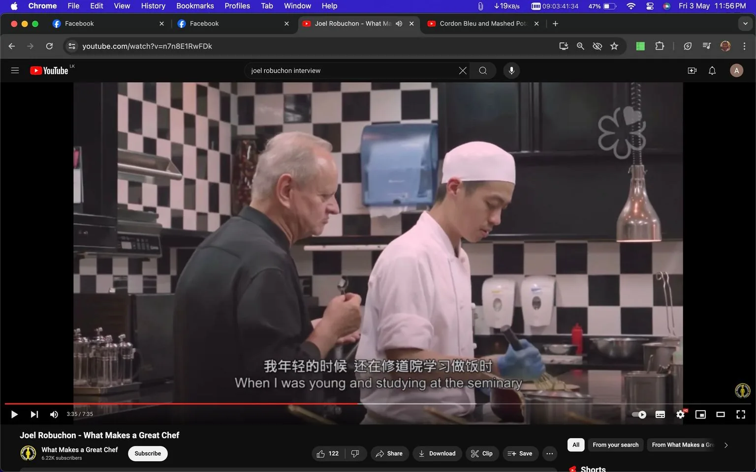 The image is a screenshot from a YouTube video titled "Joel Robuchon - What Makes a Great Chef," featured on the "What Makes a Great Chef" channel. The scene takes place in a kitchen, characterized by a black and white checkered wall, and involves two individuals. One is an older man, likely Joel Robuchon based on the title, wearing a dark chef's jacket. He appears to be instructing or observing a young chef, who is dressed in a traditional white chef's uniform with a white cap. The young chef is focused on his task, handling food with blue gloves.
The kitchen setting is professional, with stainless steel appliances, hanging lamps, and neatly organized kitchen tools, giving a sense of discipline and attention to detail. The atmosphere is industrious, as suggested by the posture and concentration of the chefs. The subtitle displayed on the screen reads, "When I was young and studying at the seminary," suggesting a narrative element where personal experiences or stories are being shared. The overall mood is educational and reflective, suitable for a video exploring the qualities of a great chef.