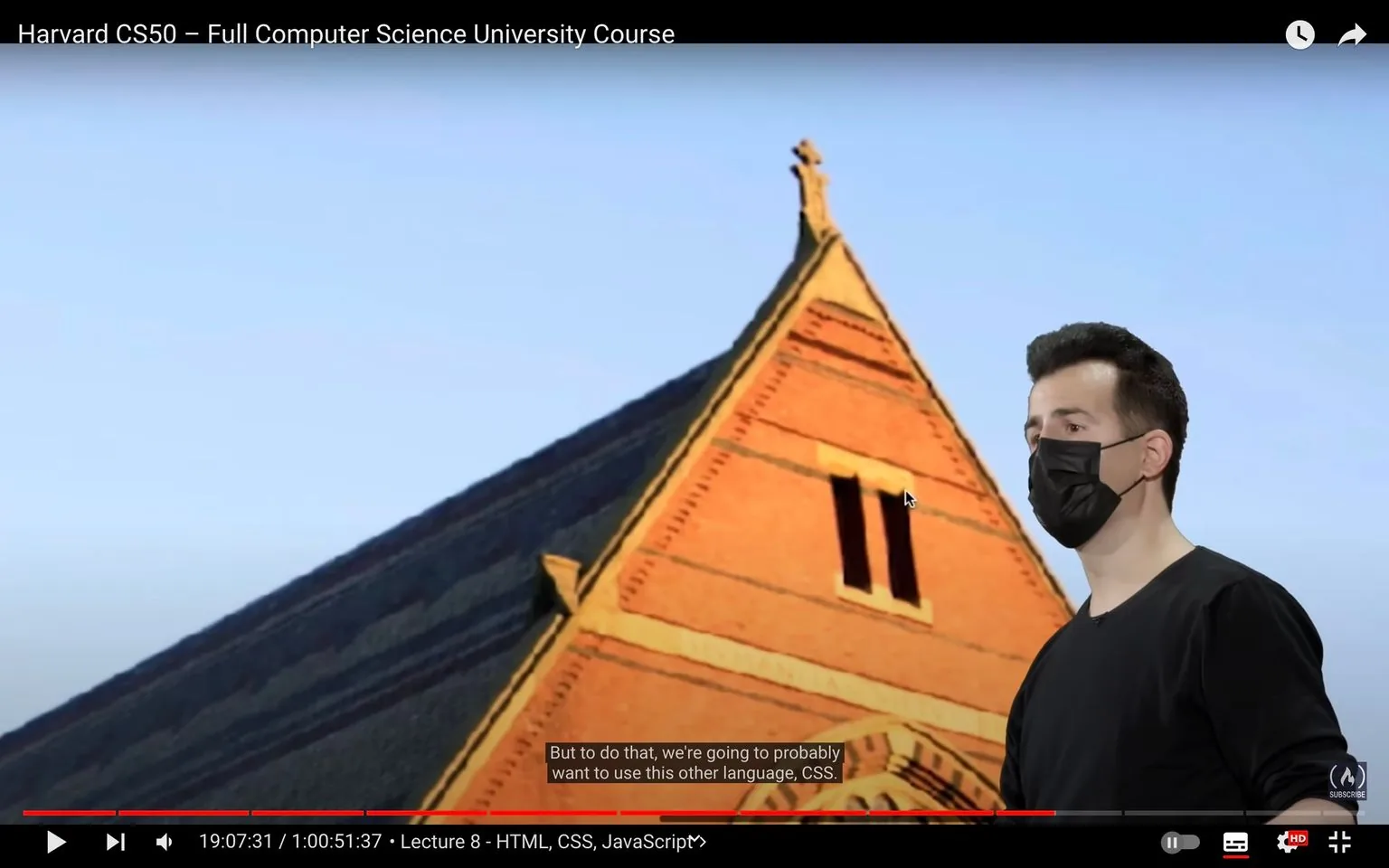 In this video frame from the "Harvard CS50 – Full Computer Science University Course," we see a person, whose identity is not specified, standing in front of an architectural backdrop reminiscent of a university building. The person is wearing a black mask and a black shirt, suggesting a formal or academic setting. Their posture is attentive and focused, possibly indicating they are delivering a lecture or presentation. The background features a striking red brick facade with dark roofing, capturing the essence of a historic or academic establishment. The lighting is bright with a clear blue sky, creating a professional and scholarly atmosphere. The subtitles provide context to the lecture, mentioning the use of CSS in web development, while the on-screen text identifies that this is Lecture 8, focusing on HTML, CSS, and JavaScript. This frame is part of an educational series aimed at teaching computer science concepts, particularly web development languages.
- Title: "Harvard CS50 – Full Computer Science University Course"
- Captions / subtitles: "But to do that, we're going to probably want to use this other language, CSS."