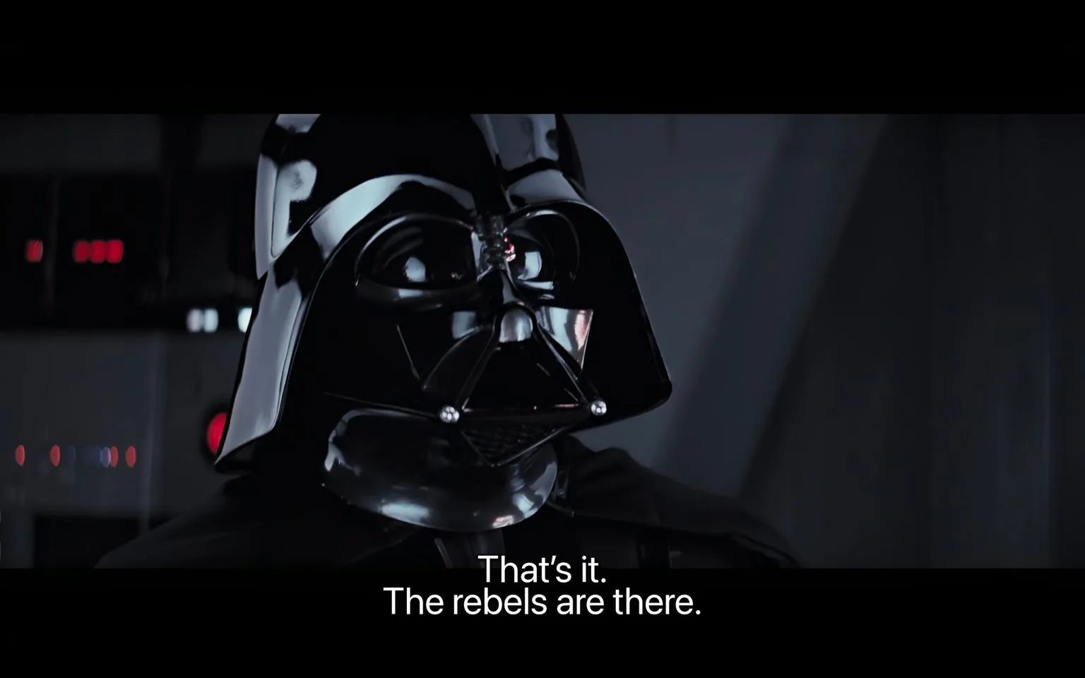 In this dramatic scene from "Star Wars," a character in a black, glossy helmet with a distinctive mask and cape is seen in a dimly lit interior. The setting suggests a futuristic or sci-fi environment, typical of the "Star Wars" series. The character, known for his iconic appearance, is staring intently, conveying a sense of determination or realization. The lighting accentuates the reflective surfaces of the helmet, adding to the ominous and powerful presence. The background features what appear to be controls or panels, reinforcing the setting's technological aspect. The caption reads, "That's it. The rebels are there," indicating a moment of discovery or strategic planning. The mood is tense and foreboding, fitting the character's authoritative and commanding nature. The use of dark colors and sharp contrasts adds to the gravity and seriousness of the scene.
- Captions / subtitles: "That's it. The rebels are there."