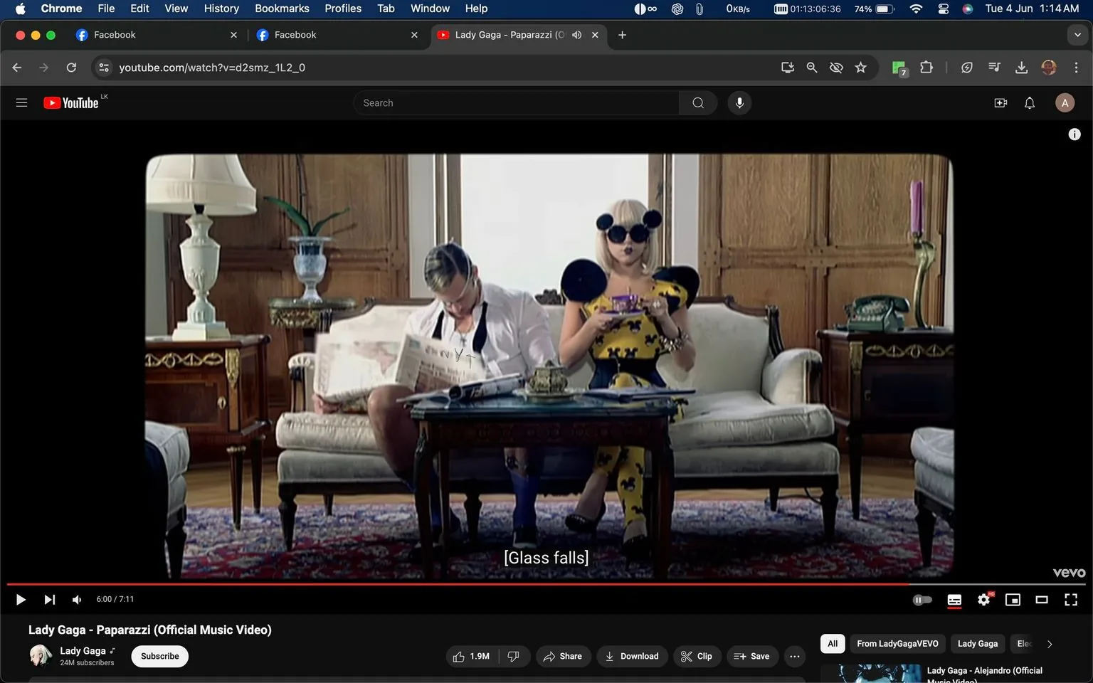 The video frame is from the music video "Paparazzi" by Lady Gaga, featured on YouTube. The scene is set in a vintage-style sitting room, characterized by wooden paneling and ornate furniture. Lady Gaga is seated on a plush, cream-colored sofa wearing a striking yellow outfit with black accents and large, circular sunglasses. Her attire is bold and eye-catching, matching the theatrical style often associated with her work. Beside her is a man in a white shirt, unbuttoned with suspenders, reading a newspaper.
The decor includes a classic lamp on a side table, a patterned rug, and a decorative telephone, contributing to the elegant and somewhat retro ambiance. The lighting is soft, enhancing the luxurious feel of the setting. The subtitle "[Glass falls]" suggests an action or event occurring off-screen. The video is published by VEVO on Lady Gaga's official channel, indicating its authenticity and association with her musical brand.