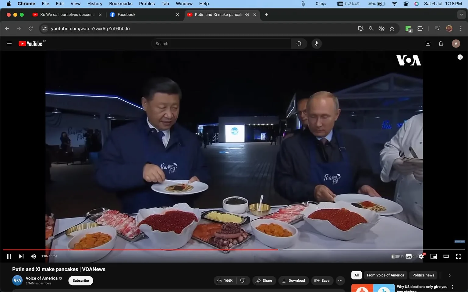 Xi and Putin are captured in a moment of culinary diplomacy, serving themselves from an array of food at an outdoor night event. The setting suggests a formal gathering, indicated by their attire; both are wearing dark blue jackets with the logo “Russian” on them, possibly indicating a themed event. Xi is engaging with the food in front of him, concentrating as he prepares a dish, while Putin looks down at his plate. The table is laden with a variety of foods, including bowls of bright red caviar, seafood, and other delicacies, evoking a sense of opulence. The lighting is bright enough to clearly illuminate their actions, but it is evident that the event takes place at night, adding a sophisticated atmosphere. The background shows a large open space with people in the distance and a structure that could be part of a pavilion or exhibit. The composition focuses on the interaction between Xi and Putin, highlighting their engagement in a shared cultural experience. The video is from VOA News, as indicated by the logo in the top right corner.
- Title: "Putin and Xi make pancakes | VOANews"
- Channel / profile: "Voice of America"
- Site / app: "YouTube"
