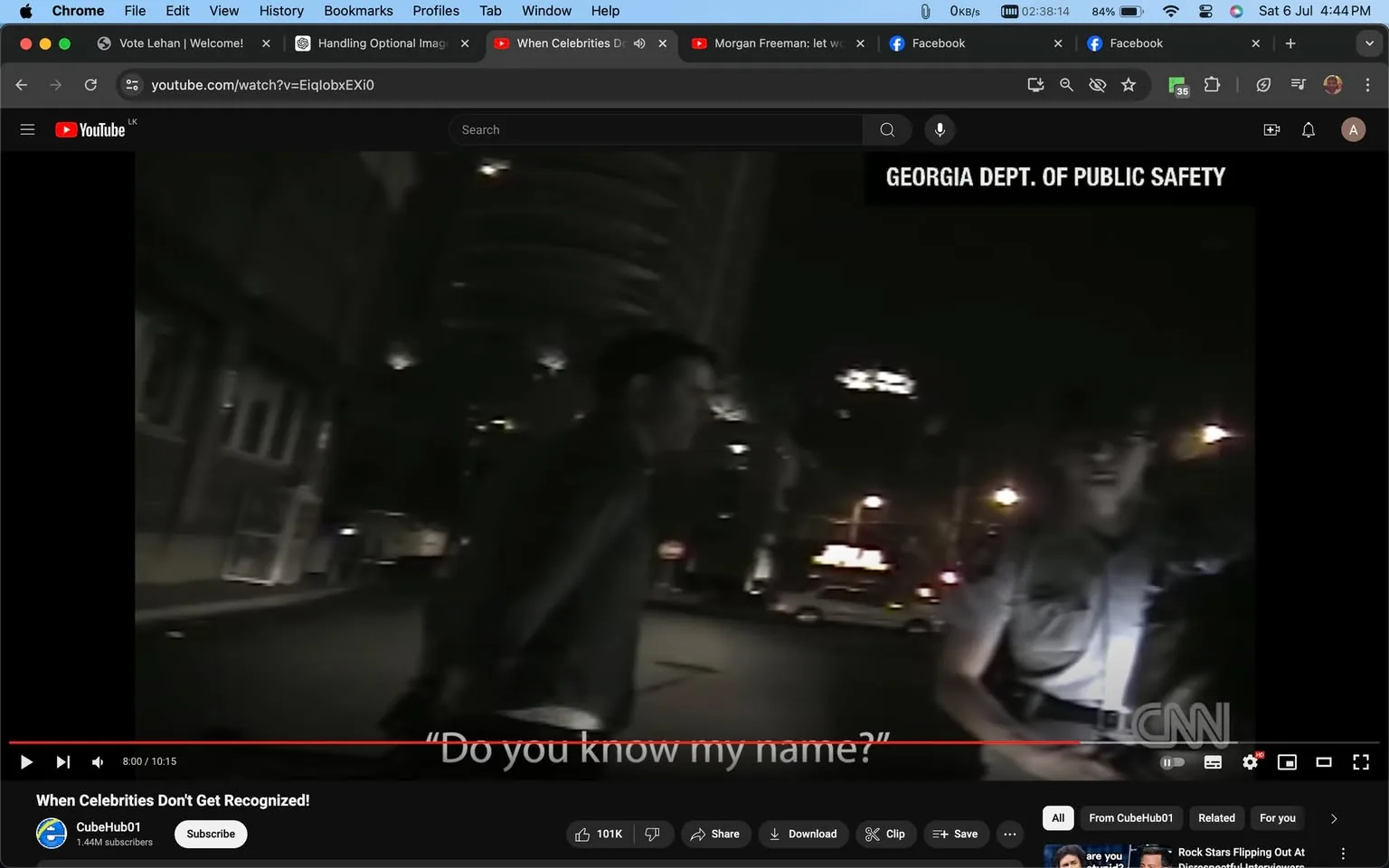 The image is a screenshot from a YouTube video titled "When Celebrities Don't Get Recognized!" on the channel CubeHub01. The video frame shows a night-time scene outdoors involving a person interacting with a police officer. The setting appears to be in a city street, with buildings and lights visible in the background. The scene is somewhat dark, indicative of nighttime, with artificial lighting illuminating certain areas.
Text on the screen includes a caption from the video, "Do you know my name?" suggesting a conversation where recognition might be a topic. The top right corner displays "GEORGIA DEPT. OF PUBLIC SAFETY" and the CNN logo appears on the bottom right, indicating the source of the footage. The person on the left is partially obscured, and the officer is in uniform, standing with a flashlight. The mood seems tense or confrontational, fitting the theme of the video which deals with celebrity recognition in public.