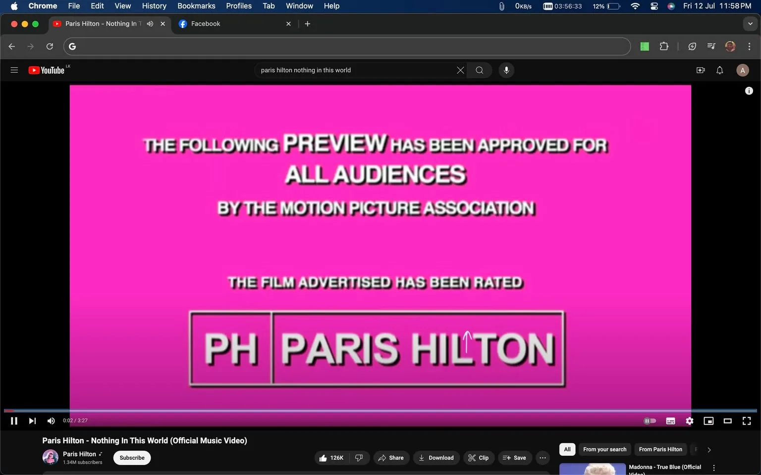 The screenshot captures part of a YouTube video titled "Paris Hilton - Nothing In This World (Official Music Video)" on the Paris Hilton channel. The image shows a vibrant pink background with white and black text typical of a movie preview screen, stating, "THE FOLLOWING PREVIEW HAS BEEN APPROVED FOR ALL AUDIENCES BY THE MOTION PICTURE ASSOCIATION." Below, it notes the film is rated with a stylized logo reading "PH PARIS HILTON." This screen mimics the format used in movie trailers to indicate age-appropriate content. The YouTube interface elements such as the video title, subscriber count, and control buttons are visible at the bottom, indicating that the user is viewing this video in a browser window. The interface is familiar, with icons for liking, sharing, downloading, and saving the video. The scene is static, focusing on the preview text, which gives a promotional feel to the video, aligning with the music industry's common practice of using cinematic styles in music video presentations.