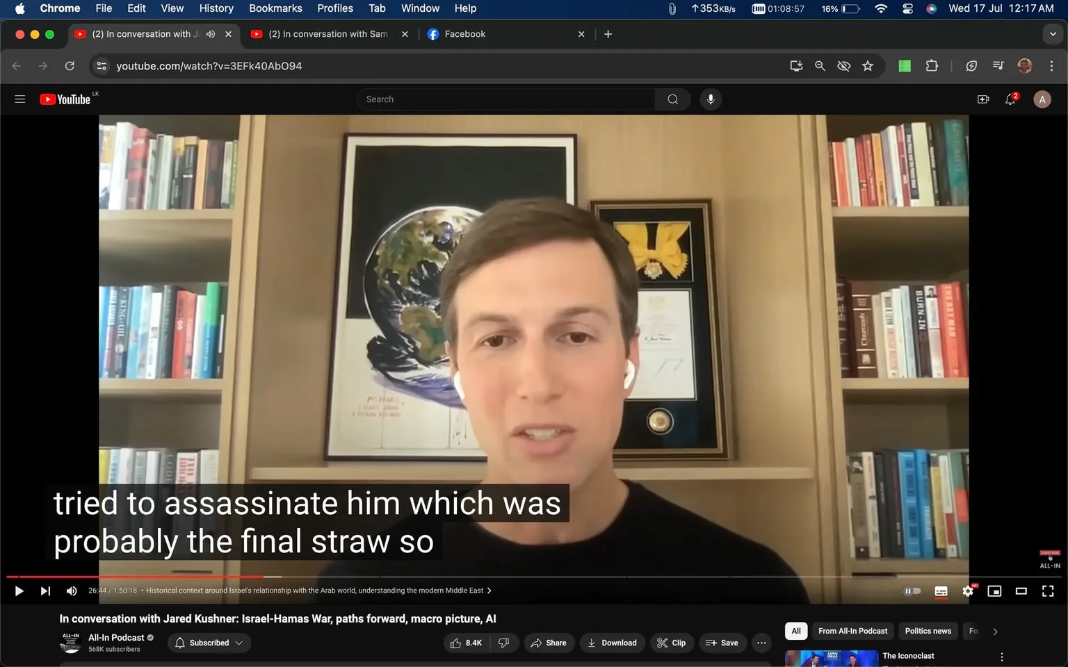 The video frame shows Jared Kushner engaged in a virtual interview, part of the "All-In Podcast" on YouTube. He appears to be speaking directly into the camera, wearing a black shirt and white earbuds. His expression is focused as he discusses a serious topic. Jared Kushner is positioned in front of a well-organized bookshelf filled with various books. Behind him, there is a framed image of Earth and a display with a golden medal, adding an academic or prestigious feel to the setting. The lighting in the room is warm and evenly distributed, highlighting the details in the background. Subtitles at the bottom of the screen capture a moment in the conversation where he mentions an assassination attempt, indicating a tense or critical discussion point. The video is titled "In conversation with Jared Kushner: Israel-Hamas War, paths forward, macro picture, AI," suggesting topics related to international relations and technological impact.
- Title: "In conversation with Jared Kushner: Israel-Hamas War, paths forward, macro picture, AI"
- Channel / profile: "All-In Podcast"
- Site / app: "YouTube"
- Captions / subtitles: "tried to assassinate him which was probably the final straw so"