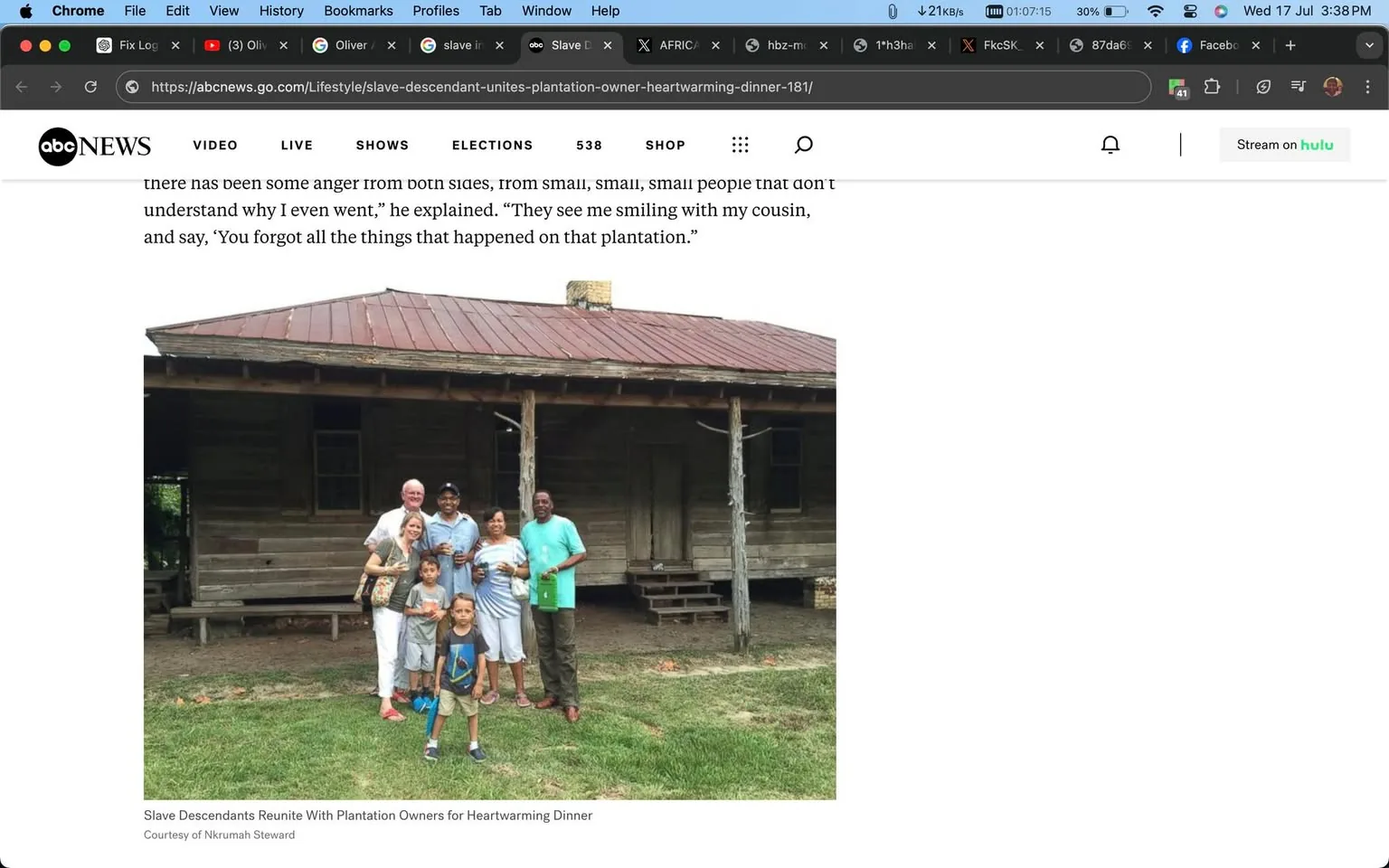 A group of people is gathered in front of an old wooden building with a rusted metal roof, typical of historical plantation architecture. The group consists of adults and children, suggesting a family or community gathering. The adults are standing closely, some with their arms around each other, holding drinks in a casual, friendly pose. Two children are in the foreground, one of whom is looking directly at the camera with a playful demeanor. The setting is grassy, with the wooden structure in the background, indicating an outdoor, possibly rural location. The image conveys a mood of reconciliation and togetherness, as suggested by the article's title. The lighting is natural, indicating daytime. The visual composition and attire of the individuals are casual, contributing to a warm and inviting atmosphere.
- Title: "Slave Descendants Reunite With Plantation Owners for Heartwarming Dinner"
- Site / app: "ABC News"
