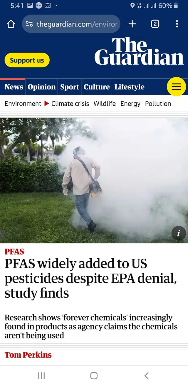 The screenshot depicts a news article from The Guardian's website. At the top, the Guardian's logo is prominently displayed against a dark blue background, alongside navigation options like News, Opinion, Sport, Culture, and Lifestyle. Below, a headline reads, "PFAS widely added to US pesticides despite EPA denial, study finds," authored by Tom Perkins. The article discusses the presence of "forever chemicals" in pesticides, despite EPA claims to the contrary.
The accompanying image shows a person in an outdoor setting, surrounded by dense fog or pesticide spray. The individual is wearing protective gear, including ear protection and a backpack sprayer, as they navigate a grassy area bordered by shrubs and trees. The scene gives a sense of active pesticide application, emphasizing the article's environmental focus. The overall composition is quite dynamic, with the person partially obscured by the mist, adding to the urgency of the environmental issue discussed in the article.