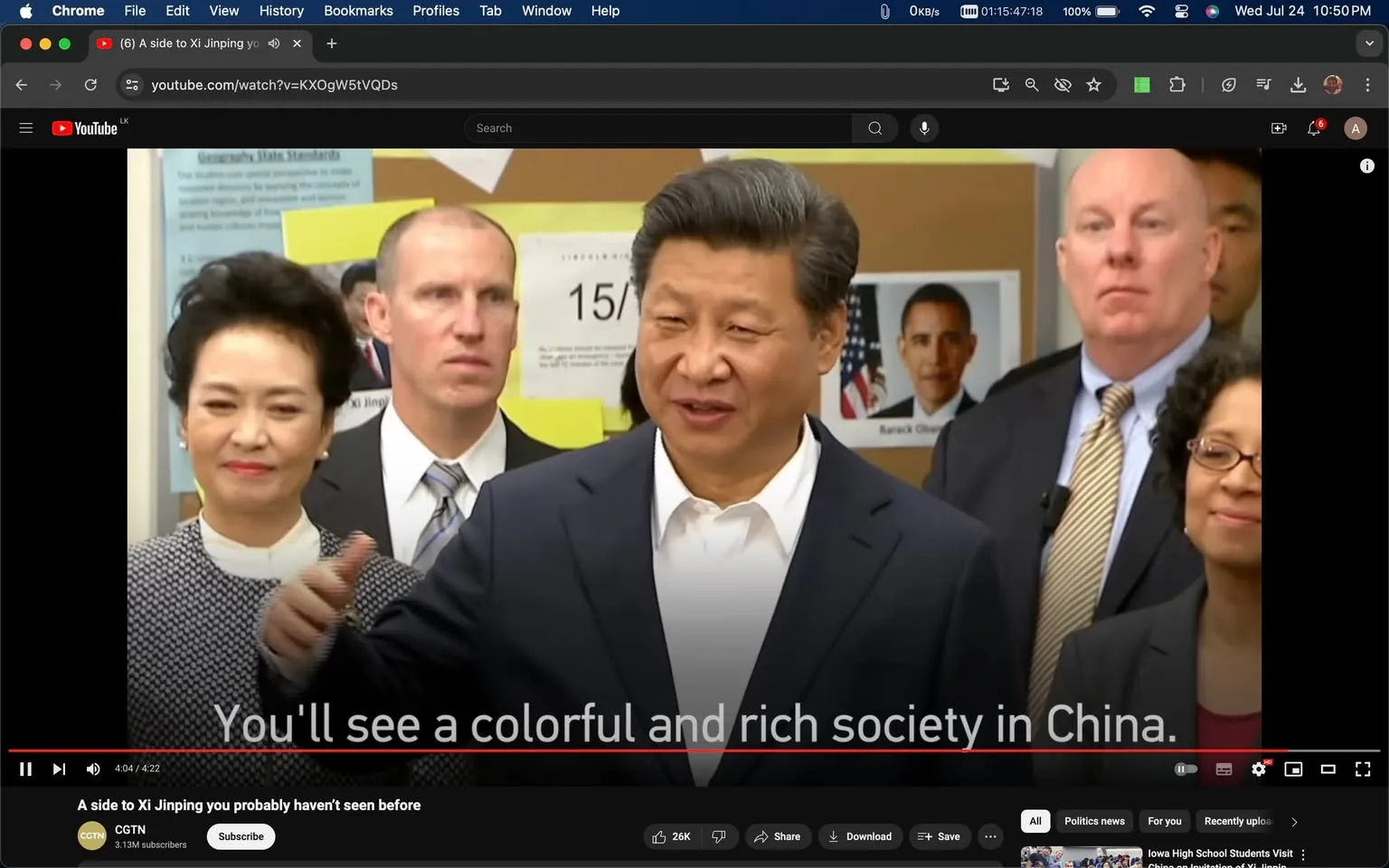 Xi Jinping is featured in this video frame, which is taken from a YouTube video titled "A side to Xi Jinping you probably haven't seen before" on the CGTN channel. Xi Jinping, positioned in the center, appears to be speaking in an indoor setting, likely addressing a group. He is wearing a dark suit with a white shirt, which adds to his formal appearance. To his left is a woman with short, styled hair, also dressed in formal attire. Surrounding them are several other individuals, including men in suits and a woman with glasses who is smiling.
In the background, there are educational materials on a bulletin board, including a visible poster of former U.S. President Barack Obama, indicating a setting that might be related to an event with international connections. The subtitle on the frame reads, "You'll see a colorful and rich society in China," suggesting the topic of discussion involves China's societal aspects. The atmosphere appears to be one of cordiality and engagement, with Xi Jinping likely sharing insights or experiences. The frame captures a moment of interaction, highlighting the presence of diverse individuals, possibly indicating a diplomatic or cultural exchange scenario.