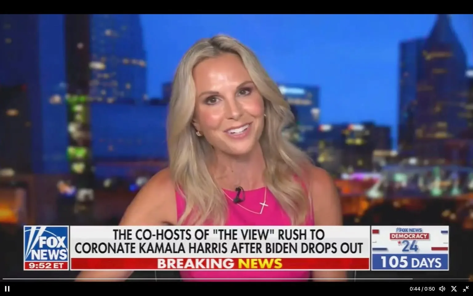 SECTION 2: Rich prose with relevant info (no fences):
1) Rich description (8–12 sentences): The screenshot features Elisabeth Hasselbeck, who is prominently positioned in the center of the frame during a broadcast on Fox News. She is wearing a vibrant pink top and a necklace with a cross pendant, and her long blonde hair is styled in loose waves. Elisabeth Hasselbeck is smiling warmly at the camera, conveying an approachable and confident demeanor. The background suggests a nighttime cityscape, with blurred lights of buildings creating a dynamic urban atmosphere. The lighting focuses on her, highlighting her expressions clearly against the darker backdrop.
The screen is filled with text, including a headline at the bottom that reads, "THE CO-HOSTS OF 'THE VIEW' RUSH TO CORONATE KAMALA HARRIS AFTER BIDEN DROPS OUT," with "BREAKING NEWS" prominently displayed in red. In the lower left corner, the Fox News logo is visible, and the current time is shown as 9:52 ET. On the right side, there is a graphic indicating "DEMOCRACY 2024" with "105 Days" highlighted, likely referring to the countdown to an upcoming election. The overall composition is typical of a news broadcast, with Elisabeth Hasselbeck as the focal point delivering or discussing the news story.
2) On-screen text block (only include lines that have real text; if a field is unknown or blank, omit that line entirely):
- Title: "THE CO-HOSTS OF 'THE VIEW' RUSH TO CORONATE KAMALA HARRIS AFTER BIDEN DROPS OUT"
- Channel / profile: "Fox News"
- Site / app: "Fox News"
