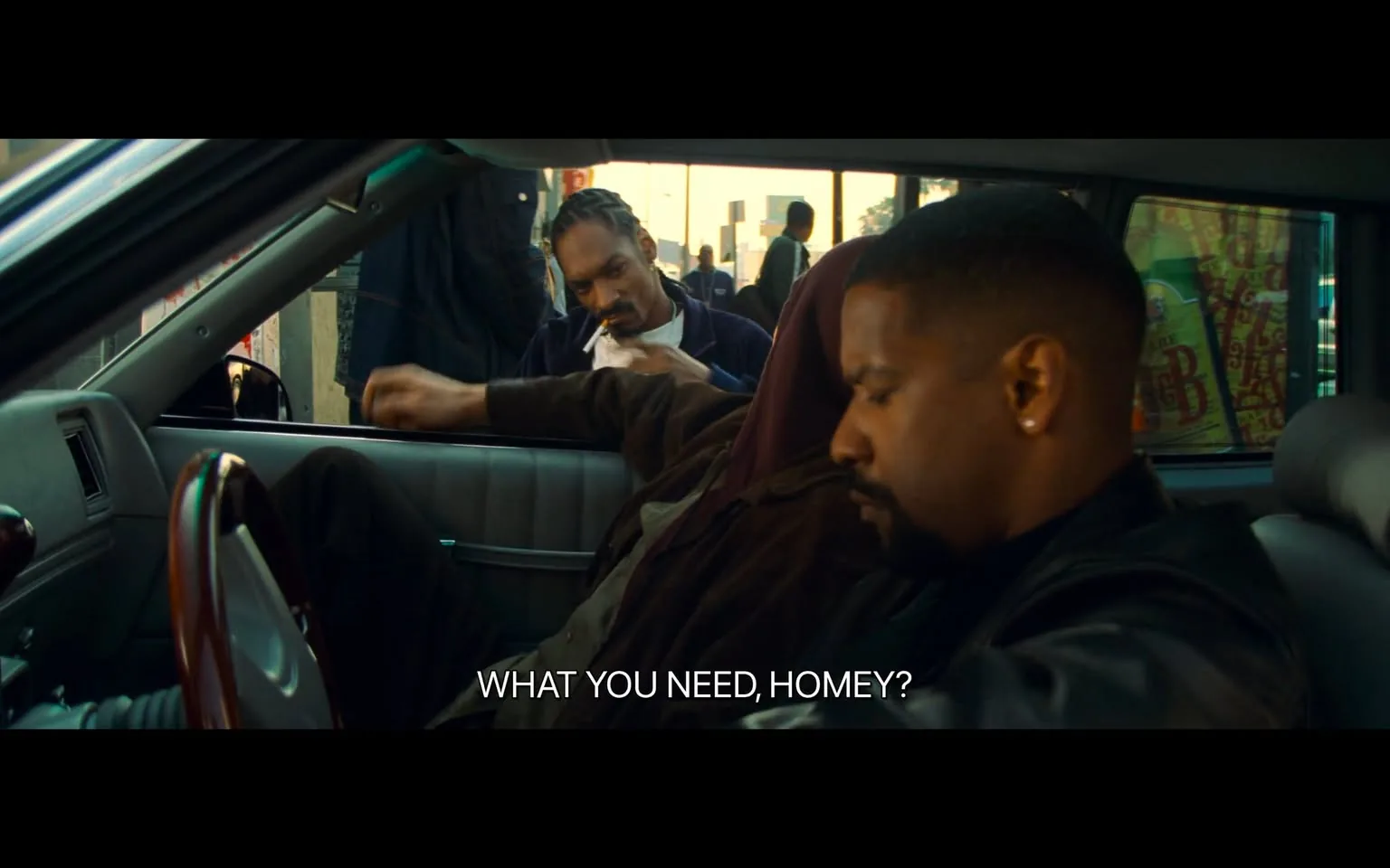 This image captures a scene set inside a parked car, with a focus on two individuals inside and one outside. Snoop Dogg is seen outside the car leaning against the passenger side window, engaging in conversation with the occupants. The person in the driver's seat is partially turned towards the window, appearing attentive yet cautious. The interior of the car is dimly lit, with a noticeable contrast between the dark tones inside and the bright daylight outside. The urban environment is hinted at by the bustling street scene visible through the car window, including pedestrians and a storefront with colorful signage. The atmosphere suggests a casual yet tense interaction, indicated by the subtitle, "WHAT YOU NEED, HOMEY?" The composition is close and intimate, drawing attention to the characters' expressions and body language, which convey a mix of curiosity and guardedness. The overall mood is one of suspense and streetwise negotiation.