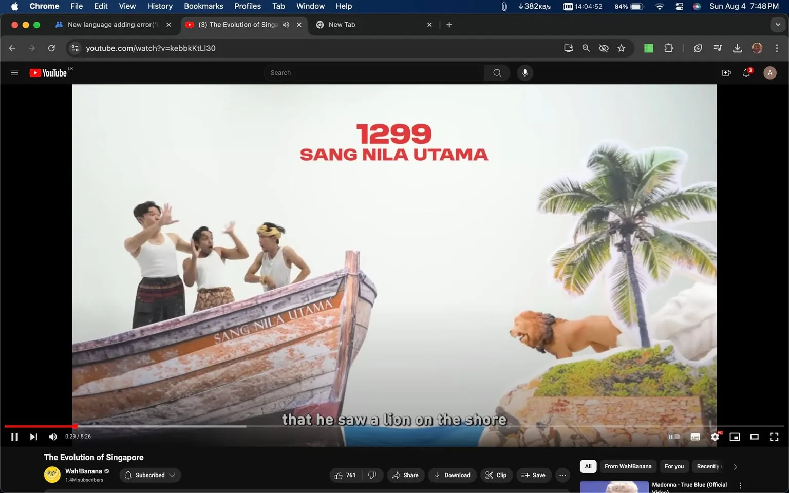 The image is a video frame from Wah!Banana's YouTube video titled "The Evolution of Singapore." It features a comedic reenactment of the historical legend of Sang Nila Utama, a figure associated with the founding of Singapore. The scene shows four people in a boat labeled "SANG NILA UTAMA," positioned on the left of the frame. They are dressed in white sleeveless tops and traditional skirts, engaging in animated gestures as if reacting to something surprising. On the right side, a stylized lion is depicted on a grassy shore with a palm tree, corresponding to the subtitle, "that he saw a lion on the shore." The background is simplistic and white, emphasizing the characters and the narrative elements. The video's style is playful and humorous, aligning with the channel's comedic approach to storytelling.
- Title: "The Evolution of Singapore"
- Channel / profile: "Wah!Banana"
- Site / app: "YouTube"
- Captions / subtitles: "that he saw a lion on the shore"