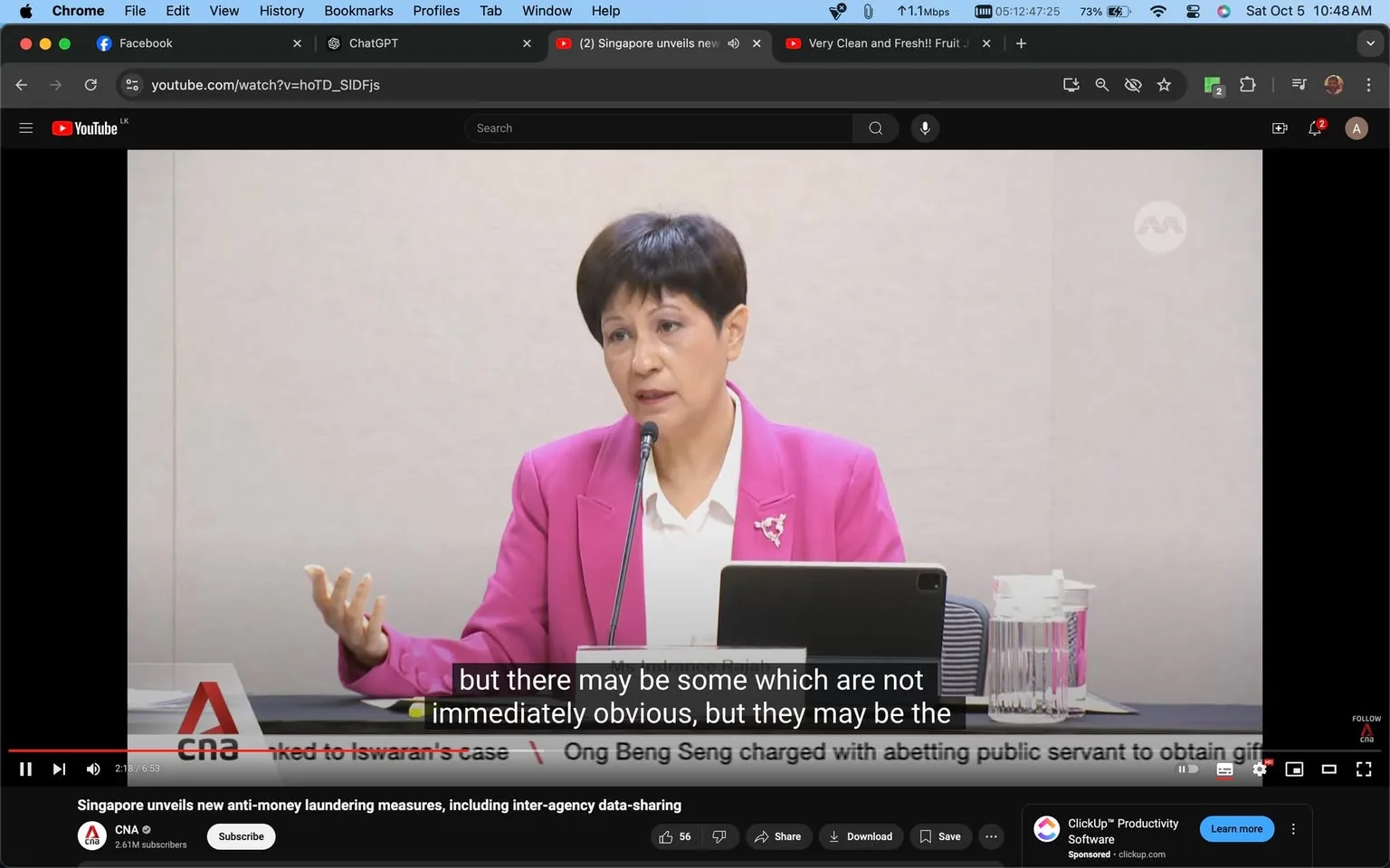 1) Rich description:
The image is a video frame from a YouTube video titled "Singapore unveils new anti-money laundering measures, including inter-agency data-sharing," published by CNA. The scene captures a woman speaking at what appears to be a press conference or formal meeting. She is dressed in a bright pink blazer over a white blouse, adding a formal yet vibrant touch to her attire. Her expression is focused and engaged as she addresses the audience, gesturing with her left hand to emphasize her points. In front of her is a microphone and a tablet, suggesting she is referring to notes or slides. The setting is likely a conference room, with a plain backdrop that keeps the focus on the speaker. The lighting is bright and even, typical of indoor media events. Superimposed text at the bottom provides subtitles for her speech, highlighting the phrase, "but there may be some which are not immediately obvious, but they may be the." The video is part of CNA's coverage on Singapore's new measures against money laundering.
2) On-screen text block:
- Title: "Singapore unveils new anti-money laundering measures, including inter-agency data-sharing"
- Channel / profile: "CNA"
- Site / app: "YouTube"
- Captions / subtitles: "but there may be some which are not immediately obvious, but they may be the"
