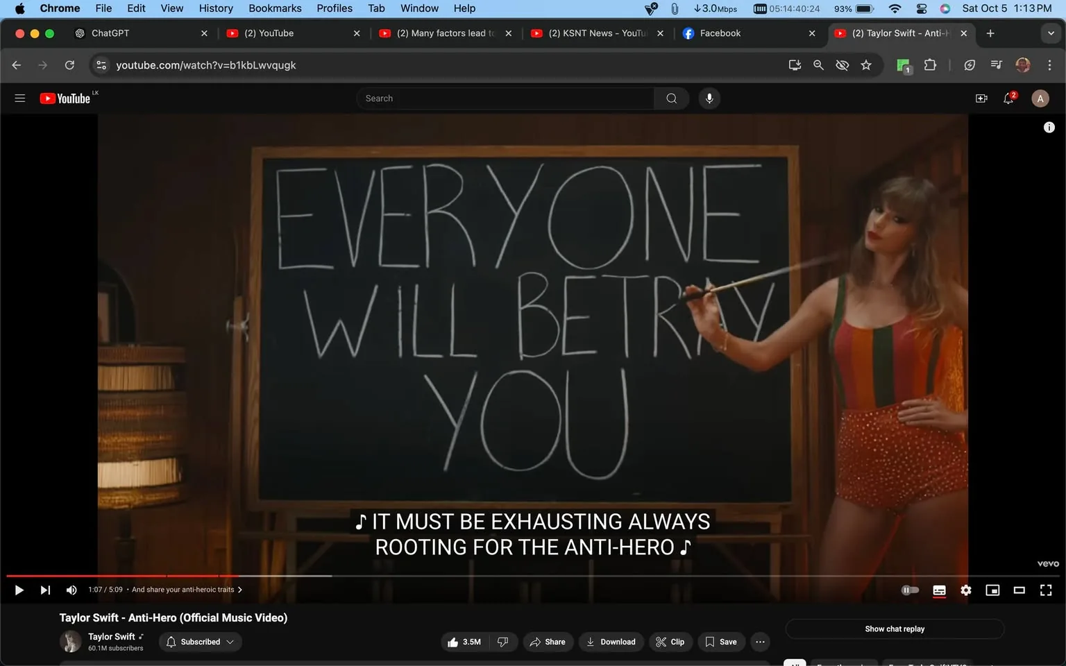 Taylor Swift is featured in this video frame from the "Anti-Hero" official music video on YouTube. She is standing inside a room, possibly a classroom or a study, in front of a large blackboard that displays the text "EVERYONE WILL BETRAY YOU" in bold, handwritten letters. Taylor Swift is holding a pointer and is pointing at the board, wearing a vibrant, multicolored striped outfit with a red, orange, and green pattern. Her posture is confident, with one hand on her hip, and she is looking directly at the viewer with an assertive expression.
The lighting is warm and the setting has a retro feel, with wooden elements visible in the background, including a lamp and shelves. The video player interface shows that this scene occurs 1 minute and 7 seconds into the video, and the subtitles display the line, "IT MUST BE EXHAUSTING ALWAYS ROOTING FOR THE ANTI-HERO." The video is published on Taylor Swift's official YouTube channel, emphasizing her pop music style and thematic exploration of self-reflection and vulnerability.