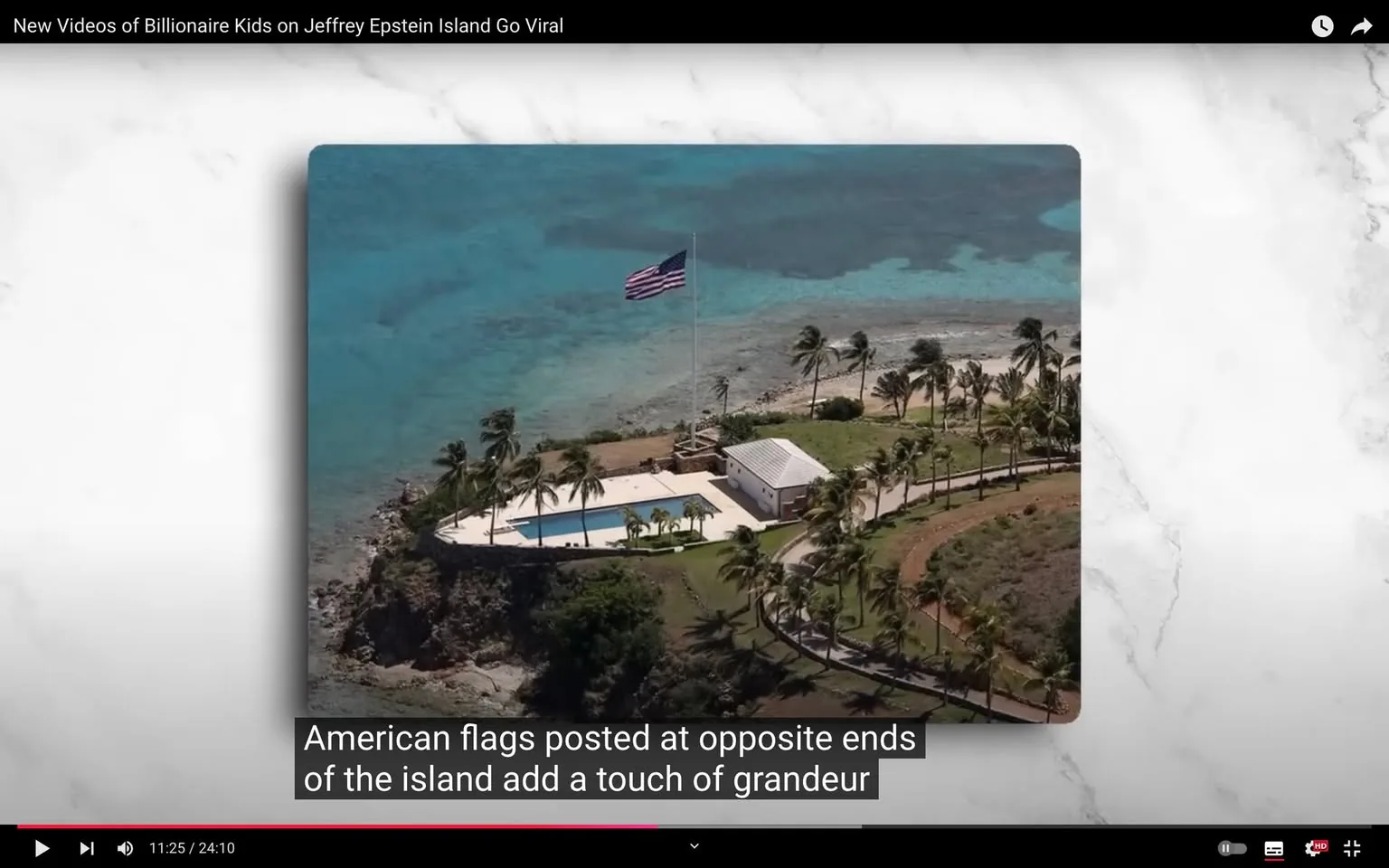 The image is an aerial view capturing a scenic section of an island, identified as Jeffrey Epstein Island. The landscape features a pool area surrounded by palm trees, with an American flag prominently flying on a tall flagpole. The setting is tropical, with turquoise waters stretching into the horizon, suggesting a peaceful and isolated atmosphere. A small white building is visible near the pool, set against a backdrop of lush vegetation and rocky coastline. The image is framed from a high vantage point, offering a broad perspective of the island's layout. The lighting is bright, indicating daytime, and the overall composition captures the luxurious and serene nature of the location. The video frame includes on-screen captions at the bottom, which mention the American flags as adding grandeur to the island.
- Title: "New Videos of Billionaire Kids on Jeffrey Epstein Island Go Viral"
- Captions / subtitles: "American flags posted at opposite ends of the island add a touch of grandeur"