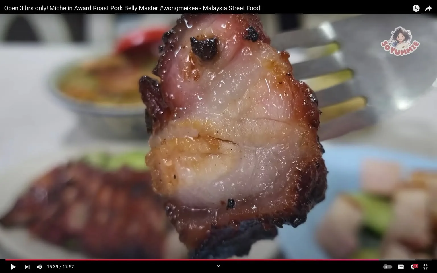 The video frame showcases a close-up of a piece of roast pork belly held by a fork. The pork belly appears succulent with a crispy, caramelized exterior, showing a balance of meat and fat that glistens under the light. This suggests a tender and flavorful bite, typical of expertly roasted pork. The background is blurred, with hints of plates and other food items, indicating a dining setting, possibly within a local street food eatery. The lighting is bright, emphasizing the juicy texture and crispy edges of the pork. The video's title suggests a focus on a Michelin Award-winning roast pork belly master, specifically highlighted by the hashtag #wongmeikee, and relates to Malaysia Street Food. The channel, "Soyummie," likely focuses on food content, capturing the essence of delicious street cuisine. The overall mood is mouth-watering and enticing, aimed at food enthusiasts and culinary adventurers.
- Title: "Open 3 hrs only! Michelin Award Roast Pork Belly Master #wongmeikee - Malaysia Street Food"
- Channel / profile: "Soyummie"
- Site / app: "YouTube"