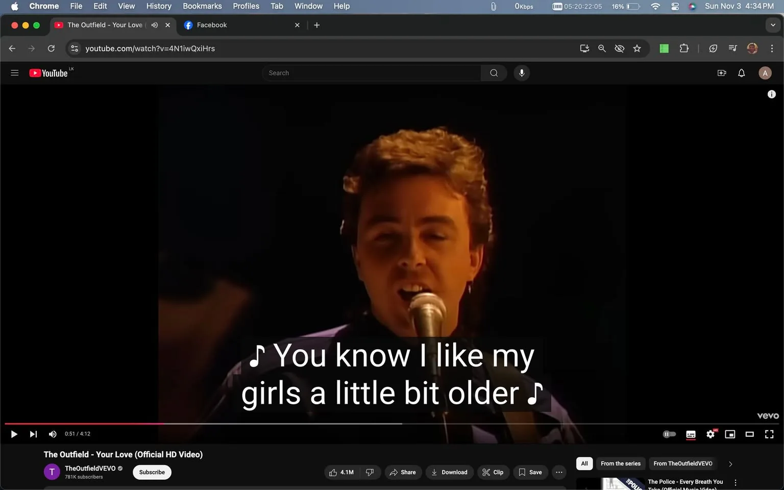 The image is a video frame from the official HD music video for the song "Your Love" by The Outfield. The scene is set in a dimly lit indoor environment, focusing on a member of the band singing into a microphone. The performer is positioned centrally, capturing the audience's attention with a direct gaze towards the camera. The lighting is soft, highlighting the musician's facial features while keeping the background out of focus. The singer's expression is one of engagement and focus, typical of a live performance setting.
The interface shows the video playing on YouTube, evident from the recognizable layout and controls, including the play/pause button and the video progress bar at the bottom. The channel "TheOutfieldVEVO" is visible, indicating the official music video channel. The video has garnered significant attention, as shown by the high number of likes and views. Captions are enabled, displaying the lyrics, "You know I like my girls a little bit older," a line from the song. The overall mood conveys a nostalgic feel, fitting for a classic 1980s music video.