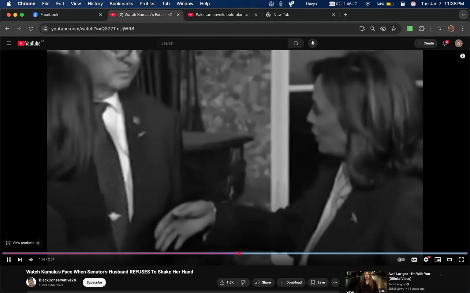 In the image, two individuals are engaged in a handshake interaction, with one person extending their hand while the other appears to be withdrawing. The setting is indoors, indicated by the presence of a decorative background and furniture. The individuals are dressed in formal attire, with one wearing a suit and tie. The scene is monochrome, suggesting it may be a still from a video. The context implies a moment of tension or discomfort, as indicated by the body language of the individuals. The video title suggests a political context, but no explicit political symbols or branding are visible.