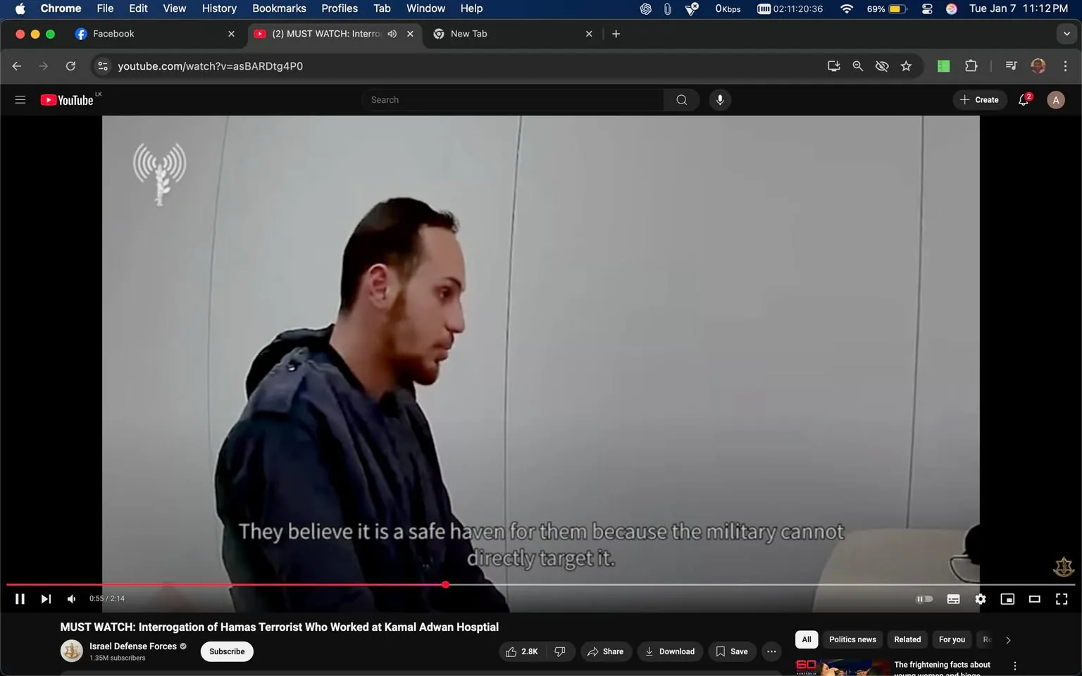 In the image, an unidentified adult male is seated, appearing to be in a tense interrogation setting. He has short, dark hair and is wearing a dark jacket. The background is minimalistic, featuring a plain white wall, which adds to the stark atmosphere of the scene. The text displayed on the screen indicates a serious discussion about safety and military actions, suggesting themes of conflict. The overall tone is somber, reflecting the gravity of the situation being discussed. The video is part of a YouTube presentation by the Israel Defense Forces, indicating a focus on military-related content.