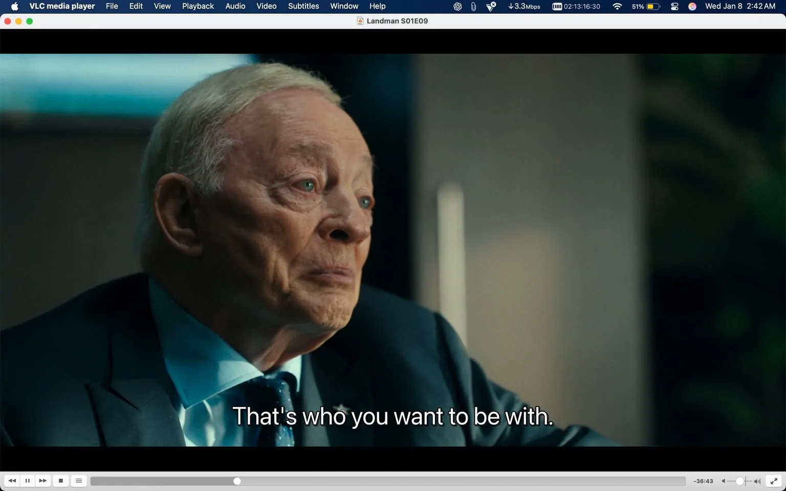 In the image, an older man with light-colored hair and a serious expression is seen, likely engaged in a deep conversation. He is wearing a dark suit with a light blue shirt and a tie, which adds to the formal appearance. The background is blurred, indicating an indoor setting, possibly an office or meeting room. The man's eyes convey a sense of concern or contemplation, and he appears to be speaking, as indicated by the text overlay that reads, "That's who you want to be with." The overall mood suggests a significant discussion taking place, though no other individuals or specific objects are visible in the frame.