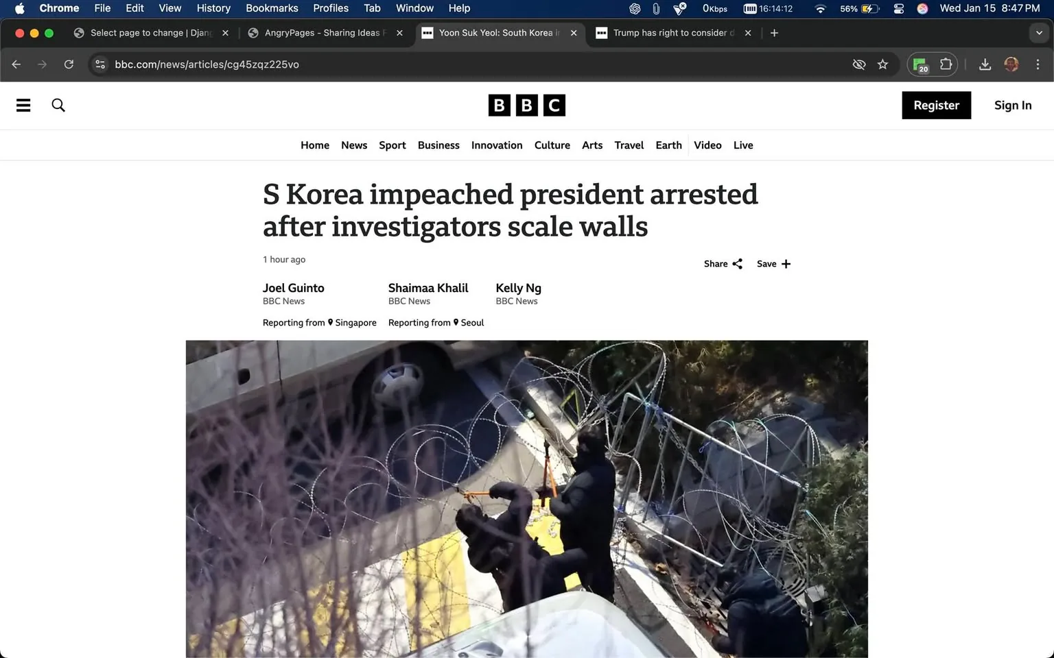 In the image, investigators are seen scaling walls, suggesting a tense situation. Two individuals, dressed in dark clothing, are actively engaged in climbing over a barrier topped with barbed wire. The setting appears to be outdoors, possibly near a vehicle, with a concrete surface visible beneath them. The presence of barbed wire indicates a heightened security or conflict scenario. The overall atmosphere suggests urgency and seriousness, likely related to the ongoing investigation mentioned in the article title regarding the impeachment and arrest of a South Korean president.