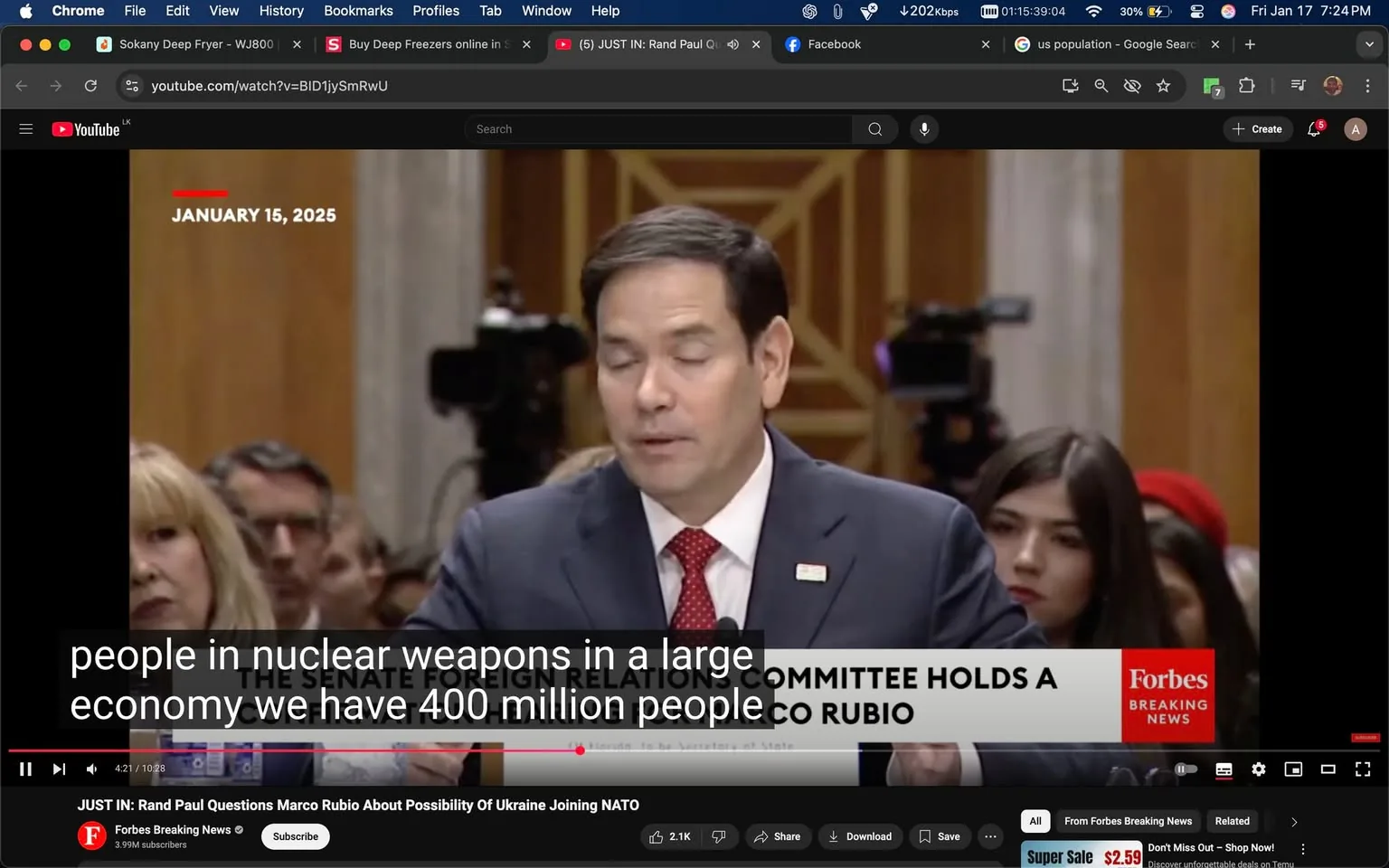 During a Senate Foreign Relations Committee hearing, a political figure is seen speaking, discussing topics related to nuclear weapons and the economy. The individual is dressed in a suit and tie, with a visible name tag on their lapel. In the background, several audience members are present, including a woman with blonde hair and another individual with dark hair. The setting appears formal, with a wooden panel backdrop and cameras positioned to capture the event. The text overlay indicates the date as January 15, 2025, and includes the logo of Forbes, suggesting the source of the video. The atmosphere is serious, reflecting the nature of the discussion.