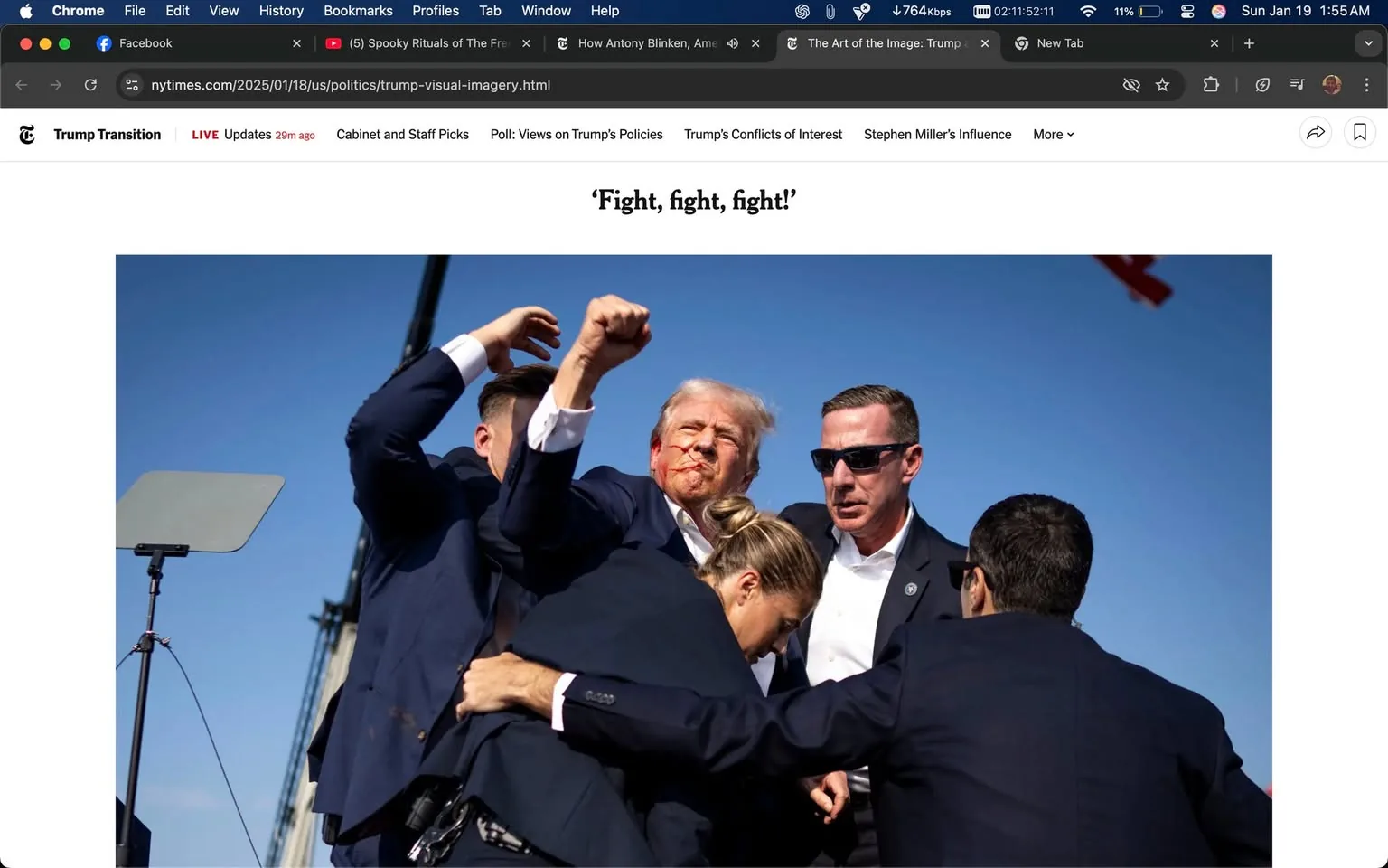 A group of individuals is engaged in a chaotic scene, with one person at the center appearing to be in distress. This individual has a facial expression that suggests anger or defiance, and there is visible blood on their face, indicating a possible injury. Surrounding them are several people in dark suits, some with their arms raised, suggesting a confrontational atmosphere. The background features a clear blue sky, and the setting appears to be outdoors, possibly at a political rally or event. The overall mood is tense, with the phrase "Fight, fight, fight!" visible in the text above, reinforcing the aggressive context.