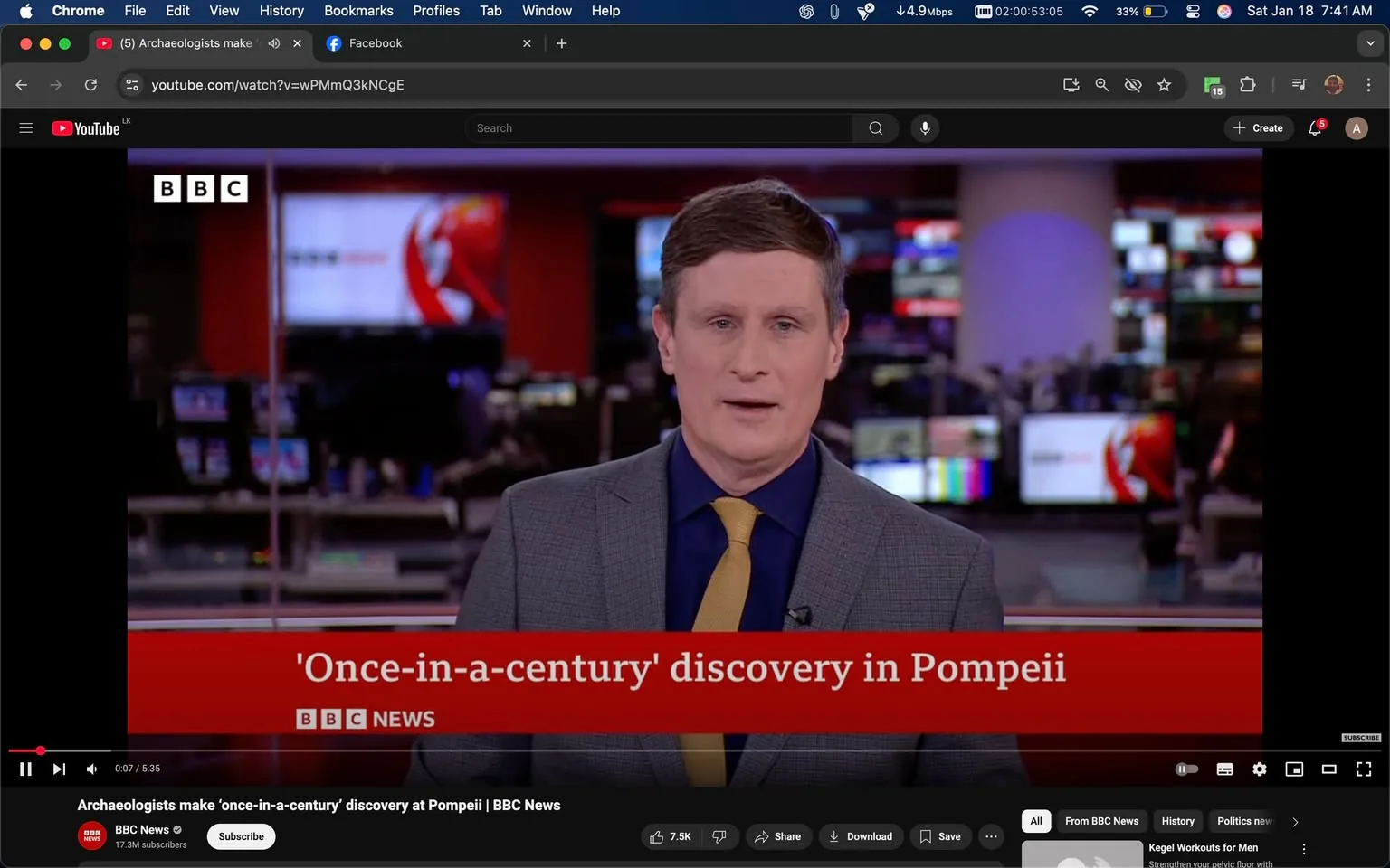 In the image, a news presenter is delivering a segment about a "once-in-a-century" discovery in Pompeii, as indicated by the text displayed at the bottom of the screen. The presenter is dressed in a gray suit with a blue shirt and a yellow tie, standing in a modern newsroom setting. Behind him, multiple screens are visible, displaying various news graphics and colors, suggesting a busy broadcast environment. The BBC logo is prominently displayed in the top left corner, confirming the source of the news. The overall atmosphere is professional and focused on delivering breaking news.