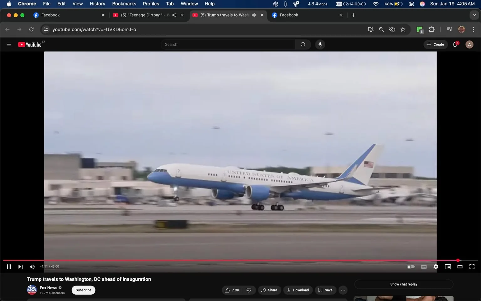 The image captures an aircraft landing on a runway, prominently displaying the text "UNITED STATES OF AMERICA" on its side. The plane is painted in a light blue and white color scheme, typical of government aircraft. The setting appears to be an airport, with a cloudy sky overhead, suggesting it may be overcast or nearing dusk. In the background, several other aircraft are visible, parked on the tarmac, indicating a busy airport environment. The focus is on the plane as it touches down, with its landing gear extended and wheels making contact with the runway. The overall atmosphere is one of anticipation, likely related to a significant political event, given the context of the surrounding posts discussing travel to Washington, DC, ahead of an inauguration. There are no visible signs of violence, sexual content, or any other sensitive material in the image.