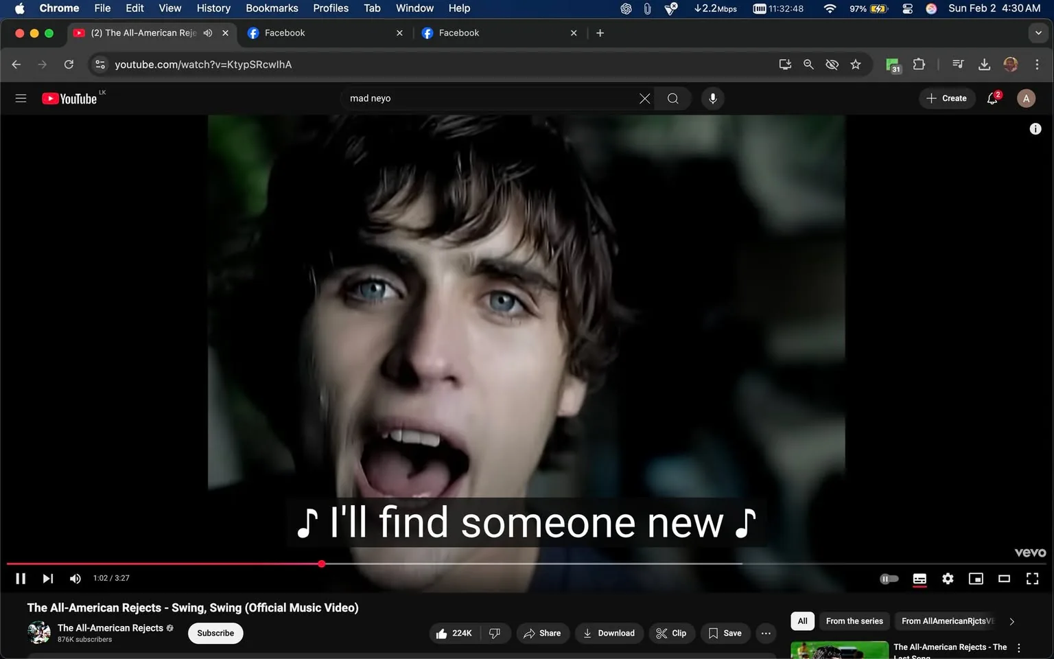 In the image, a young man with tousled dark hair and striking blue eyes is prominently featured, passionately singing into the camera. His expression conveys intense emotion, likely reflecting the lyrics of the song. The background is somewhat blurred, suggesting a music video setting, with hints of green foliage and dark shadows, creating a moody atmosphere. The text overlay at the bottom of the image includes lyrics from the song, stating, "I'll find someone new," which aligns with the themes of longing and heartbreak often found in music. The video appears to be from a performance, as indicated by the energetic delivery of the singer. The overall tone is dramatic, with the singer's open mouth and expressive face drawing the viewer's attention. The image captures a moment of vulnerability and connection, typical of emotional music performances.