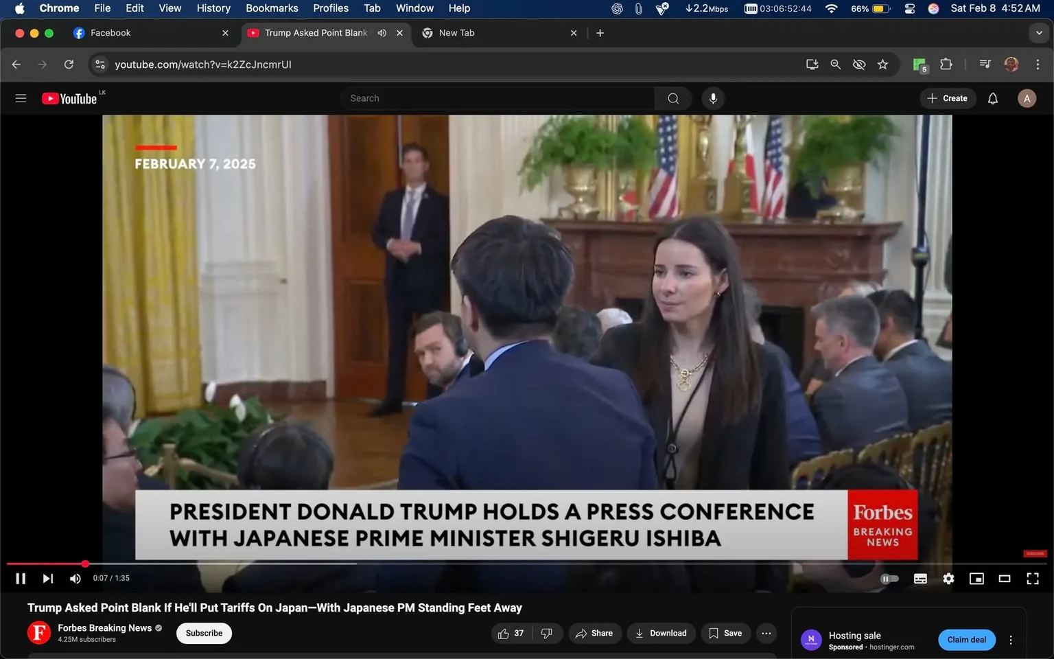 The image shows a press conference setting, likely in a formal indoor environment, possibly the White House, given the decor and flags in the background. The date displayed is February 7, 2025. In the foreground, a woman with long dark hair is engaged in conversation with a man wearing a dark suit. She appears to be in her late 20s to early 30s and is dressed in a black blazer over a light-colored top. The man she is speaking to has his back to the camera, making it difficult to discern his features. 

In the background, there are several people seated, some wearing earpieces, suggesting they may be part of the press or security. A man in a suit stands near a door, appearing to be a security personnel or aide. The room features large windows with yellow curtains, and there are American flags displayed prominently, indicating the political nature of the event. The text overlay at the bottom indicates that this is a press conference involving President Donald Trump and Japanese Prime Minister Shigeru Ishiba. There are no visible signs of violence, sexual content, or any brands other than the visible "Forbes" logo in the corner of the screen.