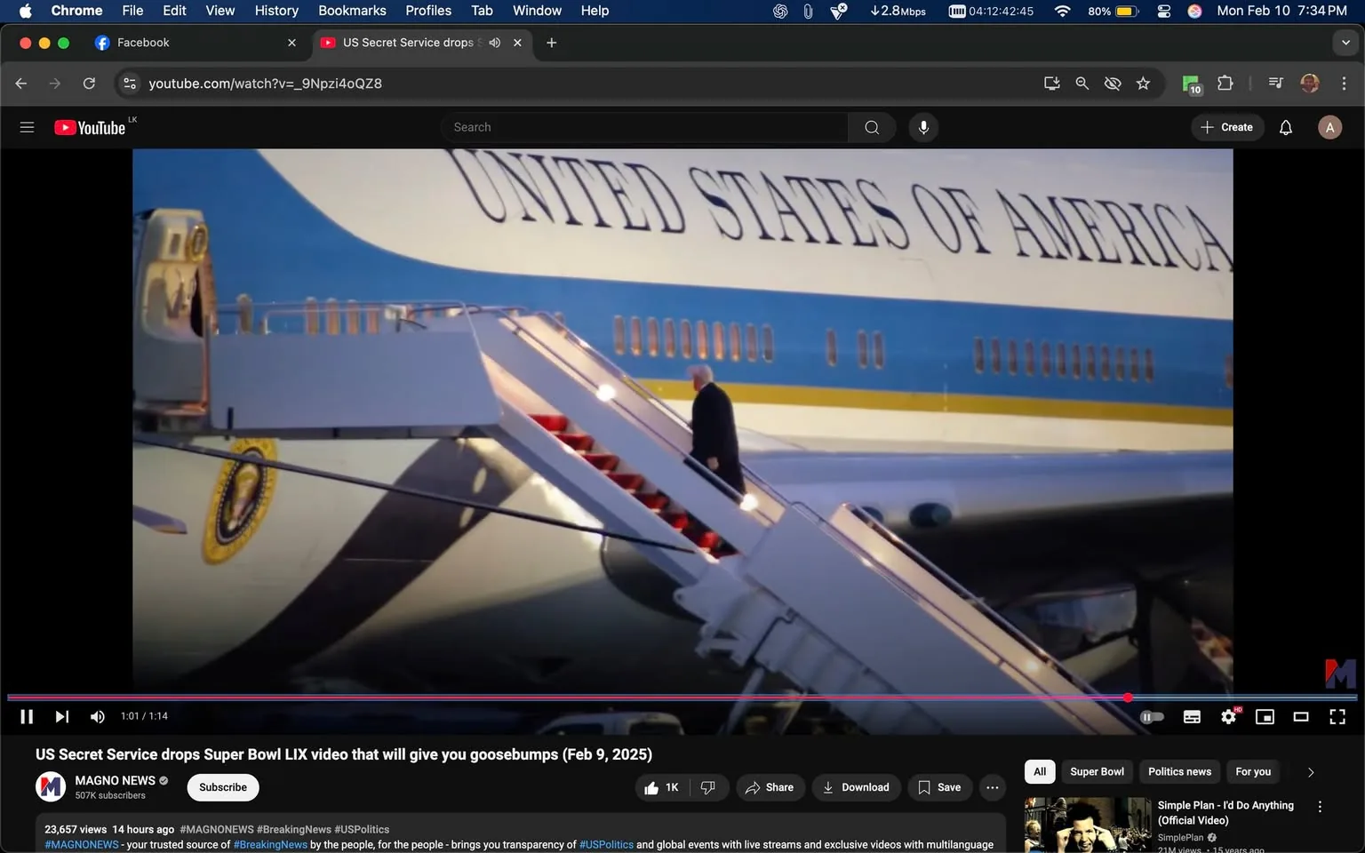 The image depicts a scene involving a large aircraft, specifically a variant of Air Force One, which is the official air transport for the President of the United States. The aircraft is painted predominantly in a light blue and white color scheme, with the words "UNITED STATES OF AMERICA" prominently displayed in large, bold letters along the side of the fuselage. Below this text, there is a yellow stripe running horizontally.

In the foreground, a set of stairs is visible, leading up to the aircraft's entrance. The stairs are white with red carpeting, indicating a formal or official setting. A figure is seen ascending the stairs, dressed in a dark suit and tie, suggesting a formal occasion. The individual is facing away from the camera, making it difficult to discern specific facial features or expressions. The figure appears to be walking with purpose.

The background features a clear blue sky, indicating that the scene is likely taking place outdoors, possibly at an airport or airfield. The lighting suggests it may be early morning or late afternoon, as the colors are warm and soft.

In the lower part of the image, there is a YouTube video player interface visible, indicating that this image is a screenshot from a video. The title of the video reads, "US Secret Service drops Super Bowl LIX video that will give you goosebumps (Feb 9, 2025)." Below the title, there are viewer statistics showing 23,657 views and a timestamp indicating the video was uploaded 14 hours ago. The channel name "MAGNO NEWS" is displayed, along with the number of subscribers (507K). Various social media interaction buttons (like, share, download) are also visible.

Overall, the image captures a moment of a formal arrival or departure involving a significant figure, likely related to a governmental or political event.