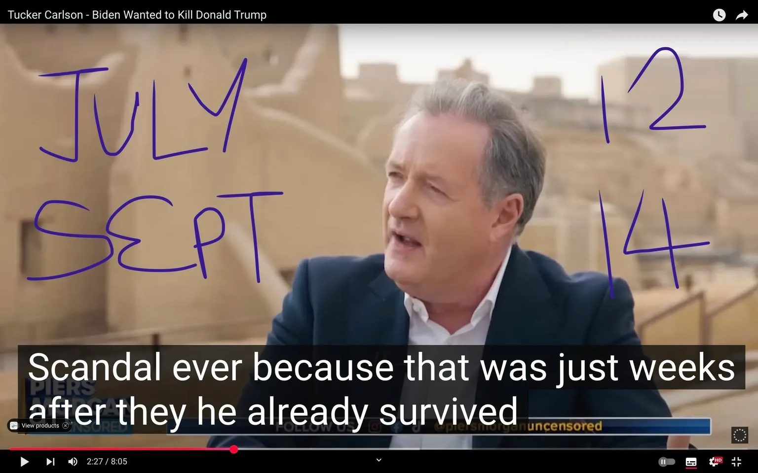 The image features a video still from a segment titled "Tucker Carlson - Biden Wanted to Kill Donald Trump." In the foreground, a man, possibly a host or commentator, is speaking. He has short, light-colored hair and is wearing a dark blazer over a light-colored shirt. His expression appears animated, suggesting he is engaged in a passionate discussion.

To the right of the man, there are handwritten notes in purple ink that read "JULY" and "SEPT" along with the numbers "12" and "14." These notes are prominently displayed and seem to be part of the visual context of the discussion.

The background consists of a blurred landscape that resembles a desert or archaeological site, with structures that appear to be ancient or historical in nature. The setting is somewhat arid, with beige and sandy tones dominating the scene.

At the bottom of the image, there are subtitles that read: "Scandal ever because that was just weeks after they he already survived." This text provides context to the ongoing conversation, indicating a discussion about political events or controversies.

The video interface is visible, showing a play button and a timeline indicating the video is at 2 minutes and 27 seconds into an 8-minute and 5-second segment. There is also a watermark or logo in the lower left corner that reads "Piers Morgan Uncensored," suggesting that this segment may be part of a broader program hosted by Piers Morgan.

Overall, the image captures a moment of political commentary, with visual elements that emphasize the discussion's urgency and context.