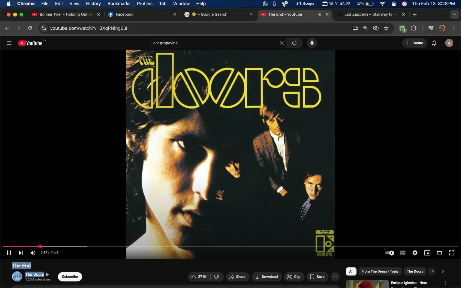 The image displays a music video interface from YouTube featuring the song "The End" by The Doors. The video player is positioned in the center of the screen, with a black background surrounding it. 

In the video player, the album cover for The Doors is prominently displayed. The cover features a close-up of a man's face, which appears to be partially shadowed, emphasizing his facial features. The man has long, dark hair and a serious expression. The background of the image shows three other individuals, slightly obscured, who are dressed in formal attire. One is wearing a light-colored suit, while another is in a dark suit with a tie. The overall color scheme of the cover is dark with bright yellow text.

The text on the album cover reads "the doors" in a stylized font, with the letters "d" and "s" appearing larger and more pronounced. The word "the" is positioned above the word "doors." The album cover is attributed to the Elektra label, as indicated by a small logo in the bottom right corner, which features a stylized "E."

At the bottom of the video player, there are controls for playback, including a play/pause button, a timeline bar, and options to share, download, or clip the video. The current playback time is shown as 0:57 out of a total duration of 11:43. Below the video player, there is a channel name "The Doors" with a subscriber count of 1.25 million.

The overall setting is digital, with no physical location or environmental context visible, as the focus is solely on the video interface and album cover. The interface is typical of a YouTube video player, with additional tabs and options visible in the browser window above the video.