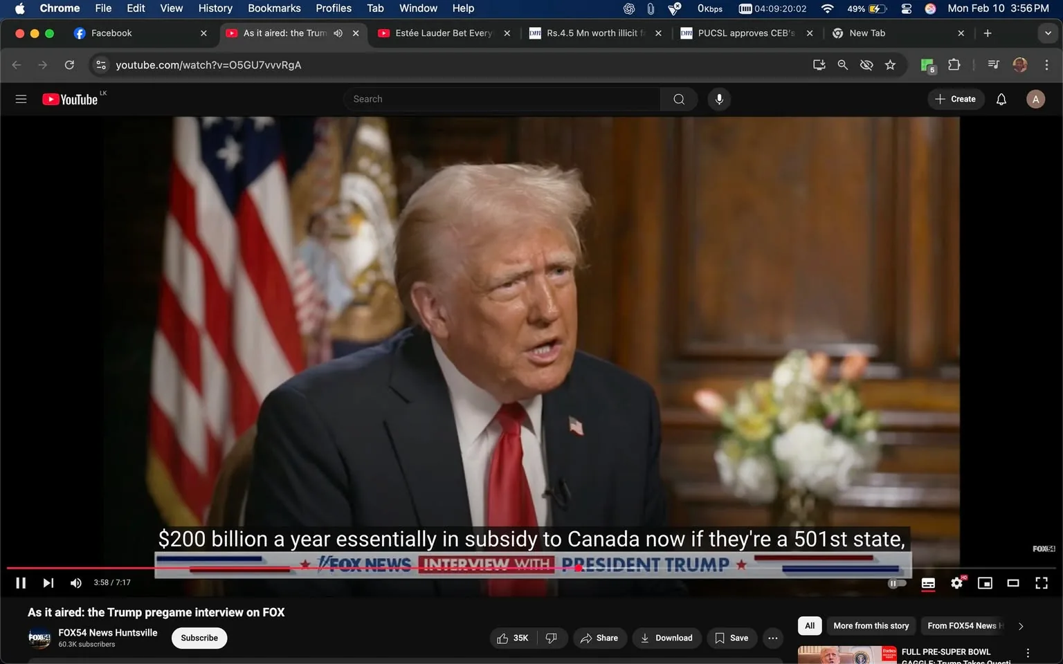 In the image, a man identified as Donald Trump is engaged in an interview, speaking directly to the camera. He appears animated and serious, discussing a financial topic related to Canada, specifically mentioning a substantial subsidy amount. The setting is formal, featuring a wooden backdrop that suggests a professional environment, likely an office or studio. In the background, there are American flags, which add a patriotic context to the discussion. A floral arrangement is also visible, providing a touch of decor to the scene. The overall atmosphere is one of a high-stakes conversation, typical of political interviews. The text displayed on the screen highlights a specific quote from Trump, emphasizing the financial implications of his statements. There are no visible minors or any content that would raise concerns regarding violence, drugs, or sexual themes.