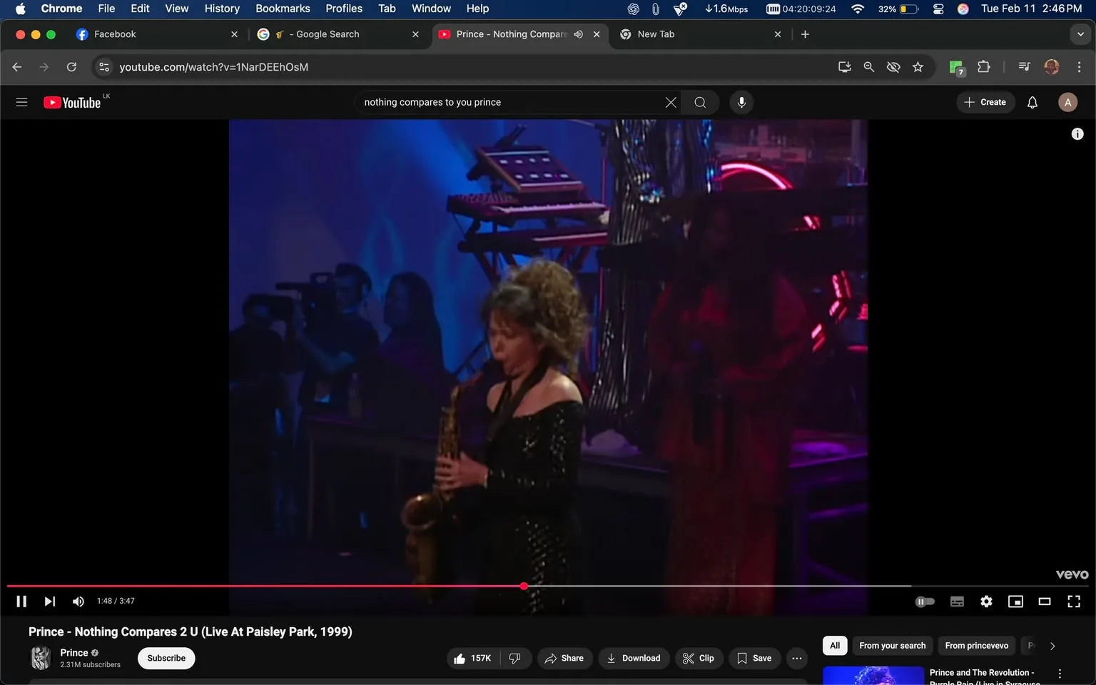 The image shows a live performance scene featuring a female musician playing a saxophone. She is positioned in the foreground, wearing a black, off-the-shoulder dress adorned with sequins that reflect the stage lights. Her hair is styled in voluminous curls. The musician appears focused on her performance, with her eyes slightly downcast as she plays the instrument.

In the background, there are several individuals, including a person holding a camera, suggesting that the performance is being recorded or photographed. The audience is partially visible, with some people in dark clothing, indicating a concert or live music event. 

The stage is illuminated with blue and purple lighting, creating a vibrant atmosphere. Behind the saxophonist, there is a keyboard setup with multiple keyboards and a neon light, which adds to the performance's visual appeal. Another performer, dressed in a long red garment, is partially visible to the right of the saxophonist, contributing to the ensemble's overall dynamic.

The video is titled "Prince - Nothing Compares 2 U (Live At Paisley Park, 1999)" and is currently playing at 1:48 out of a total duration of 3:47. The YouTube interface is visible at the bottom of the image, displaying options to like, share, download, and save the video. The channel name "Prince" is shown, along with a subscriber count of 2.31 million. 

Overall, the scene captures a moment of musical performance, highlighting the saxophonist's skill and the engaging atmosphere of the live event.