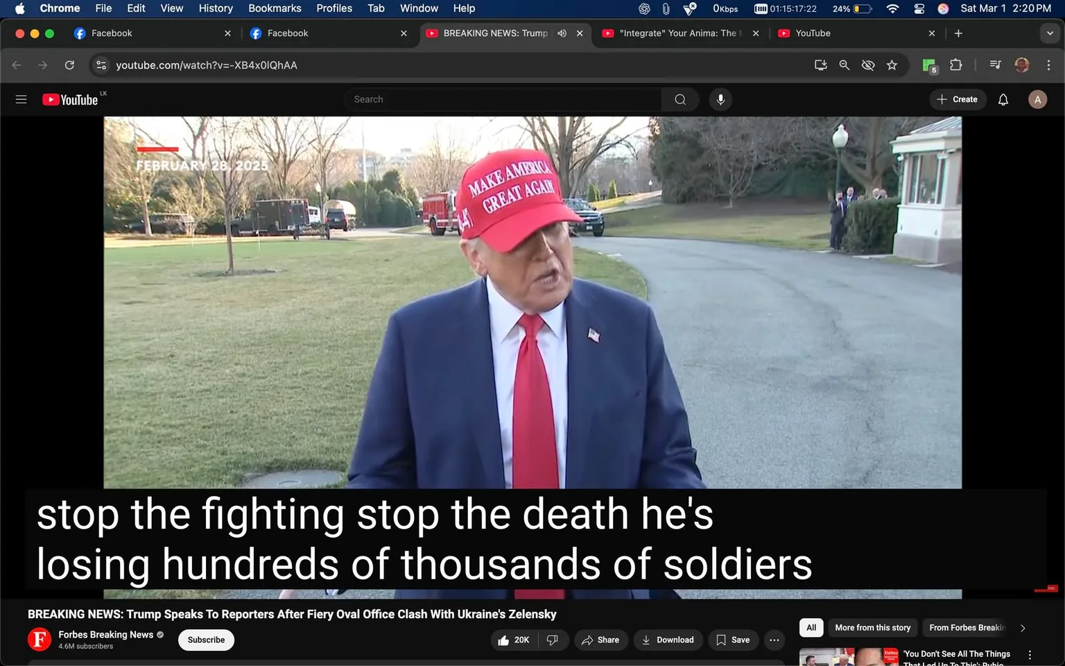 The image shows a man speaking to reporters outdoors, likely in a press conference setting. He is wearing a red baseball cap with the text "MAKE AMERICA GREAT AGAIN" prominently displayed on the front. The man is dressed in a dark suit jacket, white dress shirt, and a red tie. His facial expression appears serious as he gestures with his hands while speaking. 

In the background, there are trees that are mostly bare, indicating it may be early spring or late winter. The ground is grassy and appears well-maintained. There are vehicles visible in the background, including what looks like a black SUV and a fire truck, suggesting a secure or official location, possibly near a government building. 

At the bottom of the image, there is a caption that reads: "stop the fighting stop the death he's losing hundreds of thousands of soldiers." This text appears to be part of a video overlay, indicating the content of the speech or statement being made. 

Additionally, the interface of a video player is visible at the bottom, showing the name "Forbes Breaking News" along with a subscribe button and viewer engagement metrics, such as "20K" and "3.6M subscribers." The date displayed in the top left corner reads "FEBRUARY 28, 2023." 

Overall, the setting is outdoors, likely at a significant political or media event, with a focus on the man speaking and the surrounding environment that suggests a formal atmosphere.