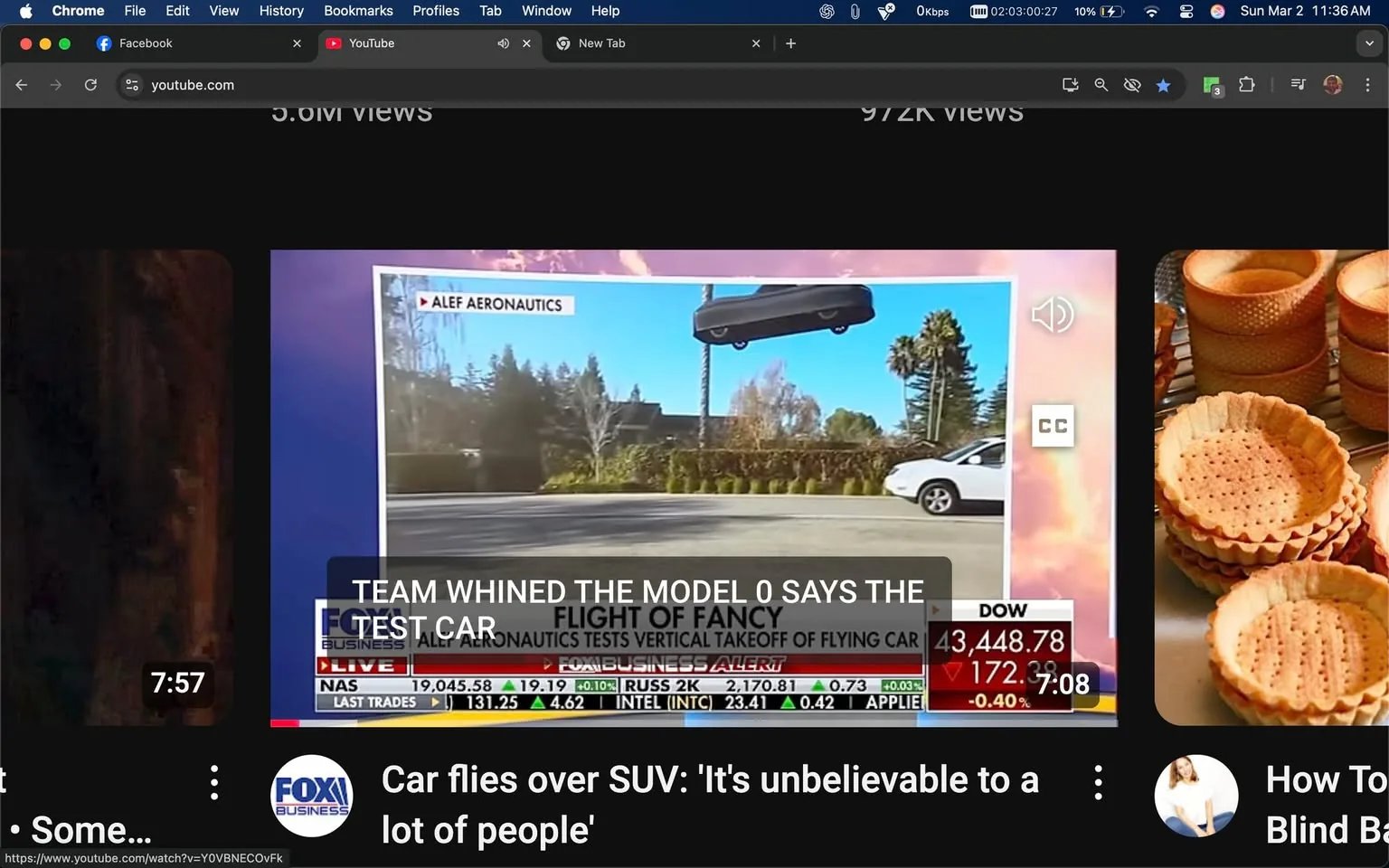 The image displays a screenshot from a video, likely related to a news segment. The main focus is a graphic featuring a flying car, which appears to be hovering above a street. The car is depicted in a sleek, modern design, primarily black, with visible wheels and a streamlined body. It is positioned above a palm tree, suggesting a suburban or urban environment.

To the left of the flying car, there is a white SUV driving on the road, indicating the presence of traffic. The background includes greenery, possibly trees or bushes, and a residential area, with houses partially visible.

In the upper left corner, there is a logo that reads "ALEF AERONAUTICS," indicating the company associated with the flying car. Below this, there is a text box that states, "TEAM WHINED THE MODEL 0 SAYS THE TEST CAR," which appears to be a headline or caption related to the segment.

The bottom of the image features a ticker with financial information, including stock indices such as NASDAQ and DOW, along with their respective numbers. The ticker is styled in a typical news format, with red and green indicators showing market changes.

Additionally, there is a caption at the bottom that reads, "Car flies over SUV: 'It's unbelievable to a lot of people,'" suggesting the content of the video discusses the flying car's capabilities and public reaction.

The overall setting appears to be a news broadcast, likely focused on advancements in automotive technology, specifically the development of flying cars. The image conveys a sense of innovation and futuristic transportation.