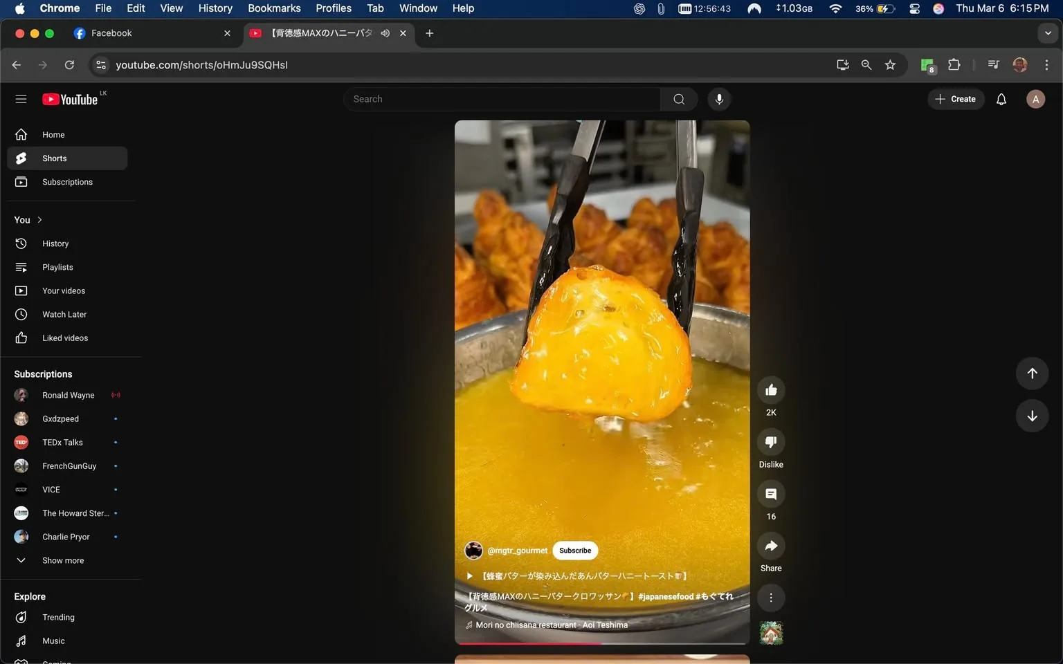 The image displays a video interface from YouTube, specifically showcasing a short video. The primary focus is on a large, golden-brown piece of food being lifted from a pot of hot oil using a pair of black tongs. The food appears to be deep-fried, with a shiny, crispy exterior, and is possibly a type of dough or batter-based item, given its texture and color.

In the background, several pieces of fried food can be seen, likely chicken or similar items, arranged on a tray. The setting appears to be a kitchen or food preparation area, indicated by the stainless steel surfaces and the general cleanliness of the environment.

On the left side of the screen, there is a sidebar typical of YouTube's layout, featuring sections labeled "Home," "Shorts," "Subscriptions," and "Explore." Under "Subscriptions," several user names are listed, including "Ronald Wayne," "Gxdzpeed," "TEDx Talks," "FrenchGunGuy," "VICE," "The Howard Stern...," and "Charlie Pryor." Each name has a small dot next to it, possibly indicating their subscription status.

At the bottom of the video, there is a caption in Japanese, which includes the handle "@mgtr_gourmet" and a description that seems to relate to the food being showcased, possibly indicating it is a type of Japanese food. The text includes hashtags like "#japanesefood" and a musical note indicating a soundtrack by "Mori no chisaina restaurant - Aoi Teshima."

The overall color scheme of the interface is dark, typical of YouTube's design, with the video content being the focal point. The image captures a moment of food preparation, emphasizing the cooking process and the appeal of fried food.