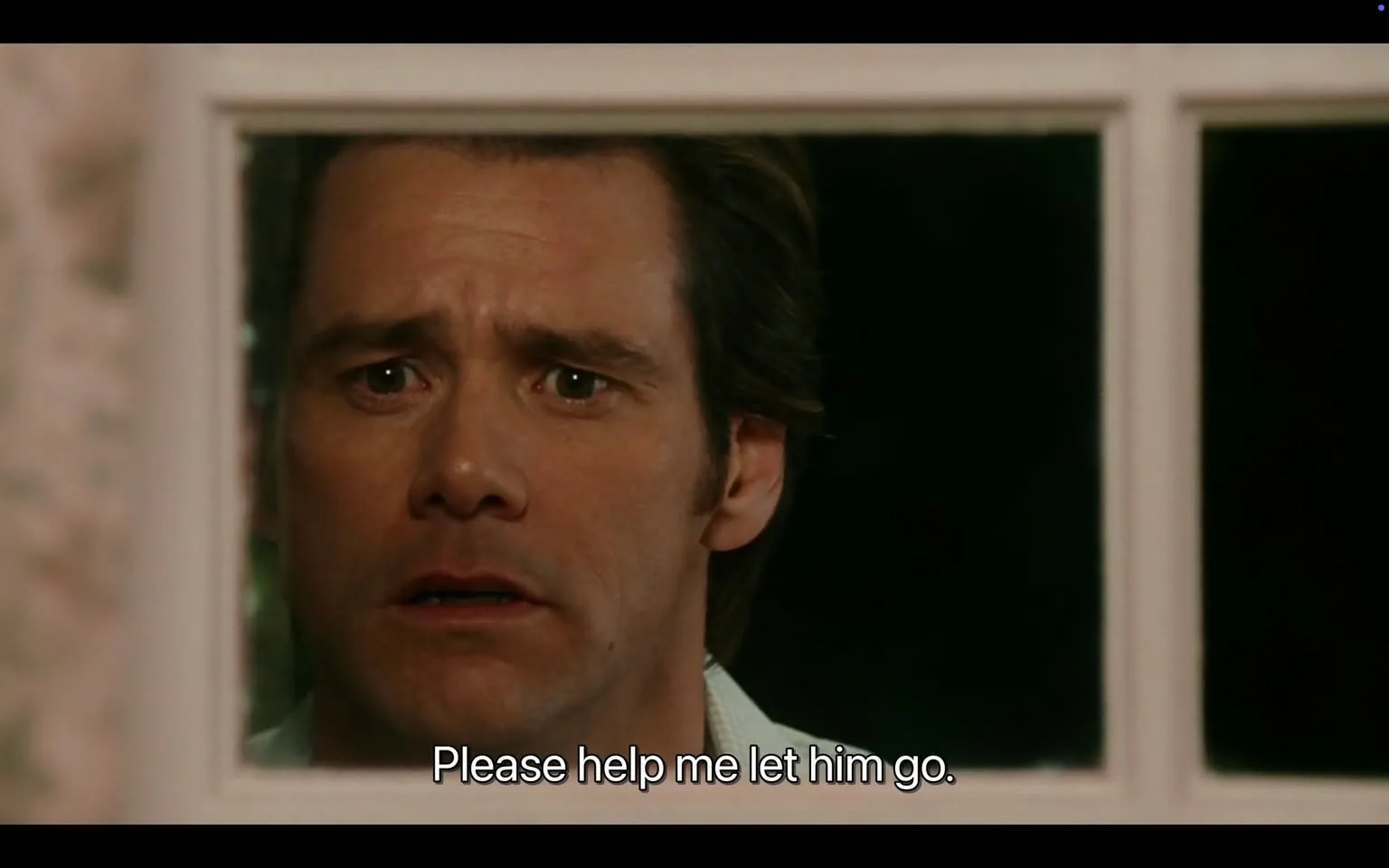 The image depicts a close-up of a man’s face, viewed through a window. He appears to be in a state of distress or emotional turmoil. His facial expression is serious, with furrowed brows and wide eyes that convey a sense of urgency or desperation. The man has short, slightly tousled hair, and his skin tone is fair. He is wearing a light-colored shirt, which is partially visible around his neck.

The window frame is white, and the background is dark, suggesting it is nighttime or in a dimly lit environment. The area outside the window is not clearly visible, but the darkness implies a private or secluded setting. The text at the bottom of the image reads, "Please help me let him go," indicating a plea or request for assistance, adding to the emotional weight of the scene.

There are no visible logos, brands, or trademarks in the image. The focus remains solely on the man’s expression and the context of the plea. The overall atmosphere is tense and somber, reflecting a moment of vulnerability.