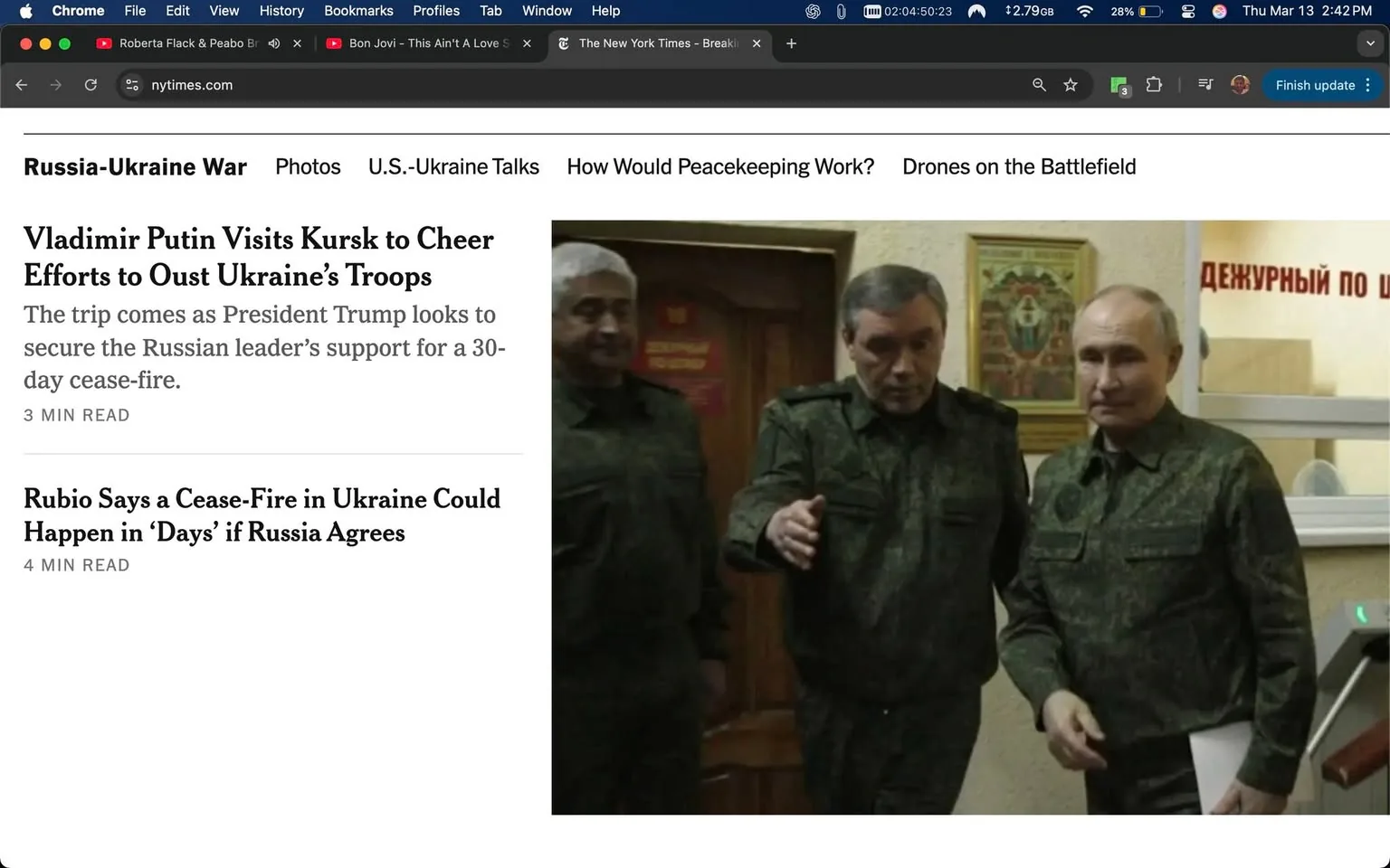 The image appears to be a screenshot of a news article from The New York Times, specifically focused on the Russia-Ukraine war. The headline reads "Vladimir Putin Visits Kursk to Cheer Efforts to Oust Ukraine’s Troops," with a subheading mentioning President Trump's efforts to secure support for a cease-fire. The article is noted to be a 3-minute read.

To the right of the text, there is a photograph featuring three men in military-style uniforms. They are dressed in dark green camouflage attire, which is typical for military personnel. The man on the right, who appears to be the most prominent figure, has short, light-colored hair and is holding a piece of paper in his left hand. He has a serious expression on his face and is looking slightly to his left. The man in the middle has a similar military uniform and is gesturing with his right hand, appearing to be in conversation. He has short, dark hair and a slightly more relaxed demeanor. The third man, on the left, has gray hair and is also dressed in military attire, standing slightly behind the others and looking towards them.

In the background, there is a wall with a decorative piece that seems to depict a coat of arms or emblem, along with some text in Cyrillic script that is partially visible. The setting appears to be an indoor location, possibly an office or a military facility, given the decor and the presence of the men in uniform.

Overall, the image captures a moment of interaction among military figures in a formal setting, with a focus on the ongoing geopolitical situation.