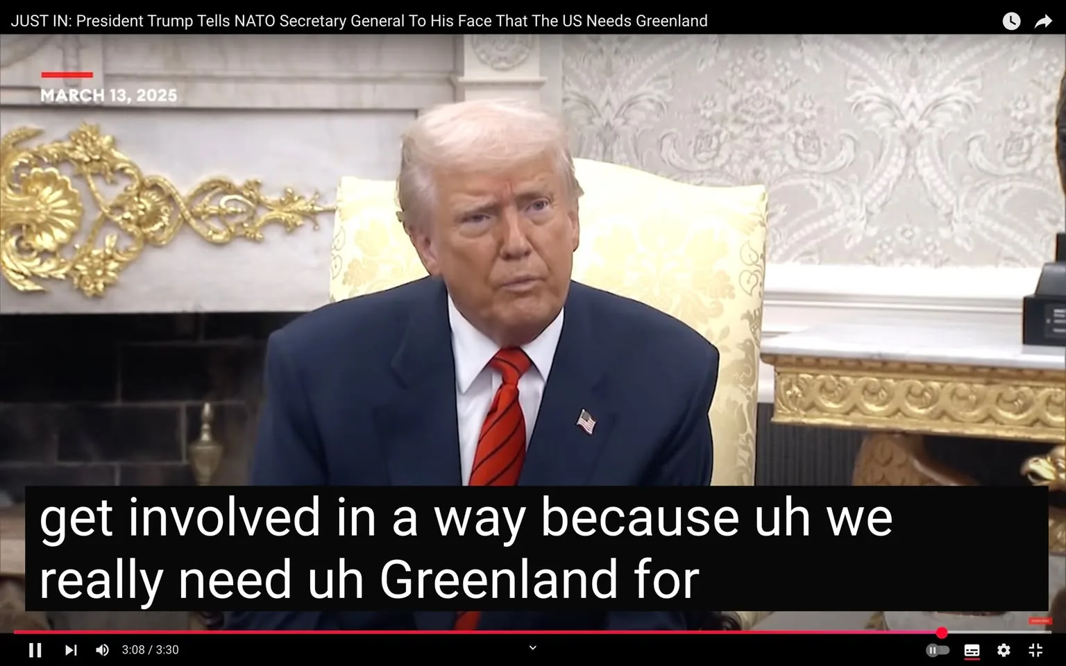 The image depicts a man seated at a table, appearing to engage in a conversation. He has light-colored hair styled in a combed manner and is wearing a dark suit with a white shirt and a red tie. The suit jacket features a small American flag pin on the left lapel. His facial expression is serious, and he appears to be speaking intently.

In the background, there is an ornate wall with a decorative pattern, likely made of wallpaper, featuring intricate designs. To the left of the man, there is a large, light-colored chair with a floral pattern, suggesting a formal setting. The table in front of him is adorned with a dark surface, and there are decorative elements, possibly a small lamp or other objects, visible on it.

At the top of the image, there is a timestamp indicating "MARCH 13, 2025." Below the man, there is a subtitle in bold, white text that reads: "get involved in a way because uh we really need uh Greenland for." The text appears to be a transcription of his speech, indicating a discussion about Greenland.

Overall, the setting suggests a formal meeting, likely within a governmental or diplomatic context, given the decor and attire of the individual. The focus is on the man speaking, with the background elements providing context to the environment.